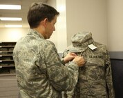 Brig. Gen. Darrell Jones, a former 37th Training Wing commander at Lackland AFB, Texas, fits an Airman Battle Uniform on a mannequin at Air Force Clothing Initial Issue Oct. 3, 2007. The new ABU comes in 236 different sizes for both male and female Airmen. (USAF photo by Robbin Cresswell)