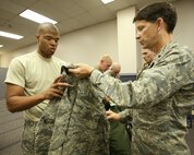 Brig. Gen. Darrell Jones, a former 37th Training Wing commander at Lackland AFB, Texas, hands Trainee Kendell Pollock the shirt of an Airman Battle Uniform at Air Force Clothing Initial Issue Oct. 3, 2007. The new ABU is being issued to all recruits entering basic military training, and replaces the battle dress uniform, which was worn by Airmen for more than 26 years. (USAF photo by Robbin  Cresswell)