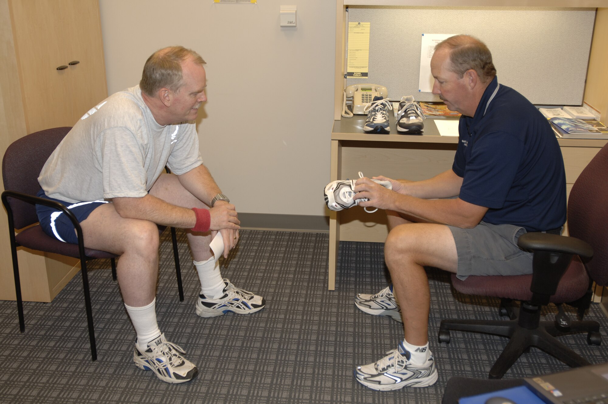 MCCONNELL AIR FORCE BASE, Kan. -- Bart Patterson, Health and Wellness Center health technician, shows Lt. Col. Jon Woods, 931st Operation Support Flight, what type of shoe he should be running in, Oct. 1 at the HAWC.  A person will need new running shoes if their shoes show these signs: worn out, wrinkled, or separation. (U.S. Air Force photo by Airman 1st Class Roy Lynch III)