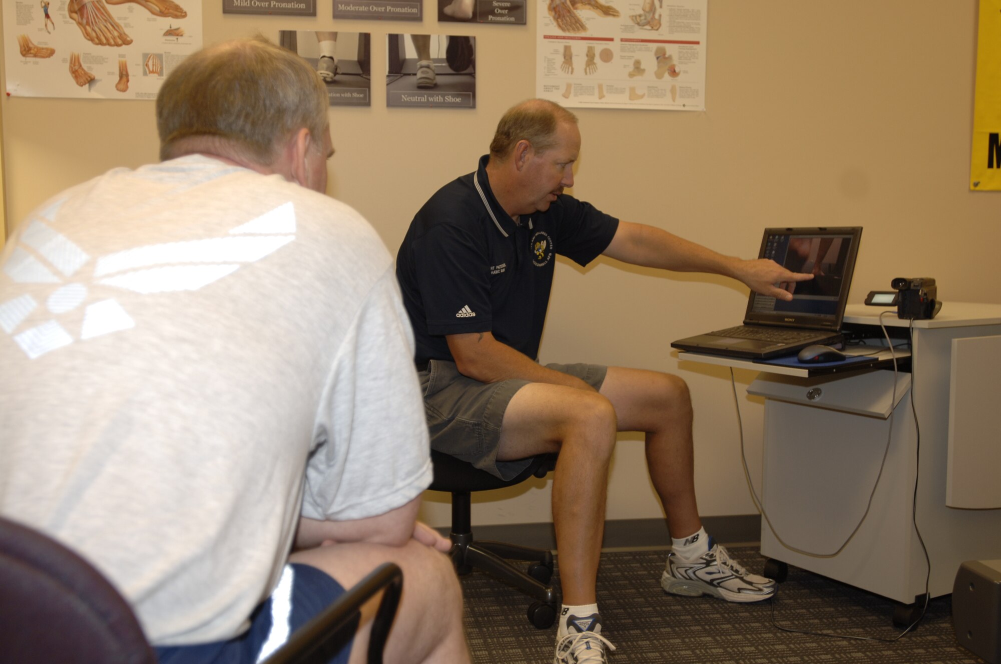 MCCONNELL AIR FORCE BASE, Kan. -- Bart Patterson, Health and Wellness Center health technician, shows Lt. Col. Jon Woods, 931st Operation Support Flight, how his bio-mechanics are working for a running shoe evaluation Oct. 1 at the HAWC.  By using the footage, Patterson can show how a person is performing. (Photo by Airman 1st Class Roy Lynch III.) 