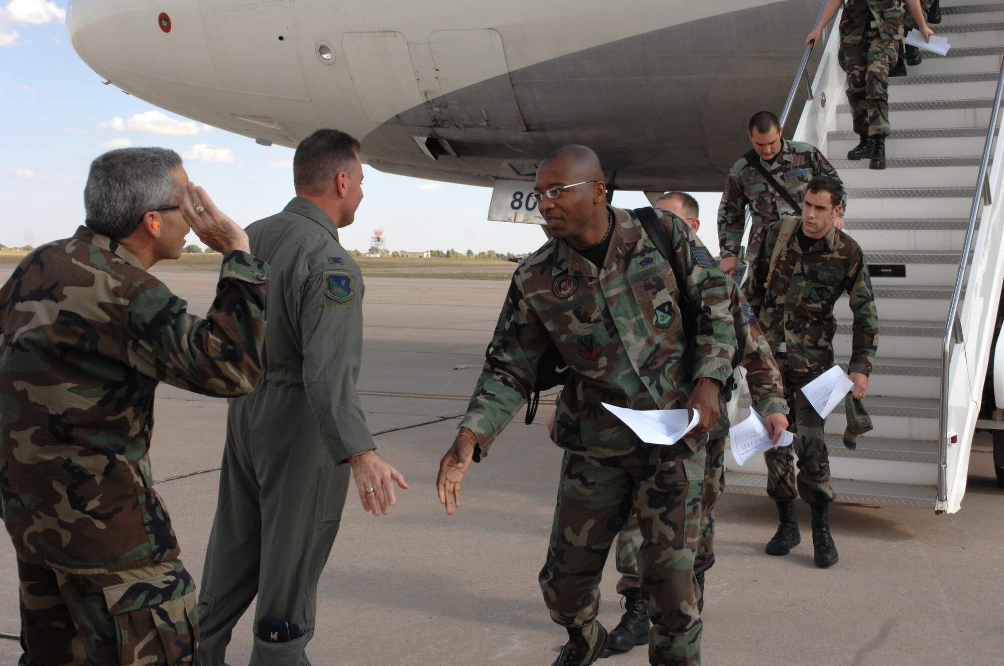CANNON AIR FORCE BASE, N.M. - (From left to right) Col. Valentino Bagnani III, 27th Special Operations Wing vice commander, and Col. Timothy Leahy, 27th SOW commander, congratulate Tech. Sgt. Jethro Brown, 522nd Aircraft Maintenance Unit, on his return to Cannon from the 522nd AMUs deployment to Guam. The Airmen left a Fighter Wing base and returned to a Special Operations Wing base. (U.S. Air Force photo by Airman 1st Class Evelyn Chavez)