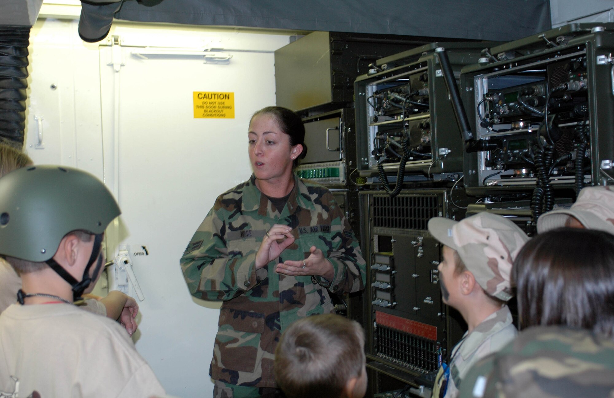 Airman 1st Class Danette Wise, 573rd Global Support Squadron, describes the different communication radios during the Kids Understanding Deployment Operations event Oct. 3. Military family members also viewed demonstrations from the 60th Civil Engineer Squadron's Explosive Ordinance Disposal robot, fire department and the 60th Services Squadron’s Mobile Kitchen Unit. (U.S. Air Force photo/Staff Sgt. Candy Knight)
