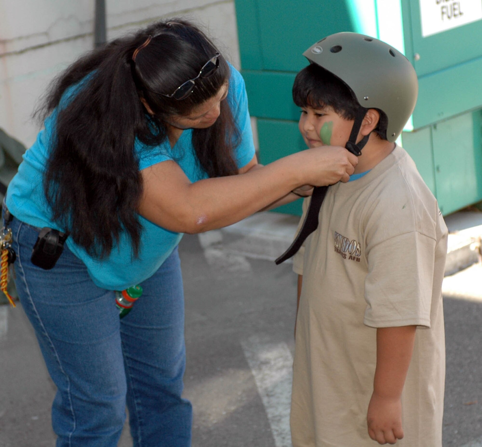 Jenelle Salas, wife of Joseph Salas, 60th Logistics Readiness Squadron, adjust son Nicholas' helmet during the Kids Understanding Deployment Operations event Oct. 3. Better known as KUDOS, the 60th Services Squadron-sponsored event was designed to give family members a realistic observational understanding of what servicemembers go through before, during and after deployments. (U.S. Air Force photo/Staff Sgt. Candy Knight)