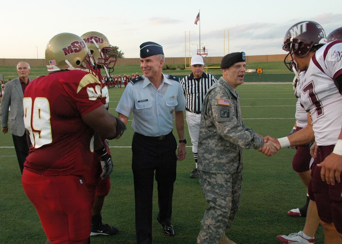 Maj. Gen. Peter Vangjel, right center, commanding general of Ft. Sill, Okla., and Brig. Gen. Richard Devereaux, 82nd Training Wing commander, offer well wishes to football players from Midwestern State University in Wichita Falls and West Texas A&M from Canyon, Texas, before their Oct. 6 football game at Memorial Stadium in Wichita Falls. Both schools took the opportunity to honor the nation's military during the MSU Salute to the Military. Thousands of military members from all services attended the game, including more than 1,500 from Sheppard. (U.S. Air Force photo/Harry Tonemah)