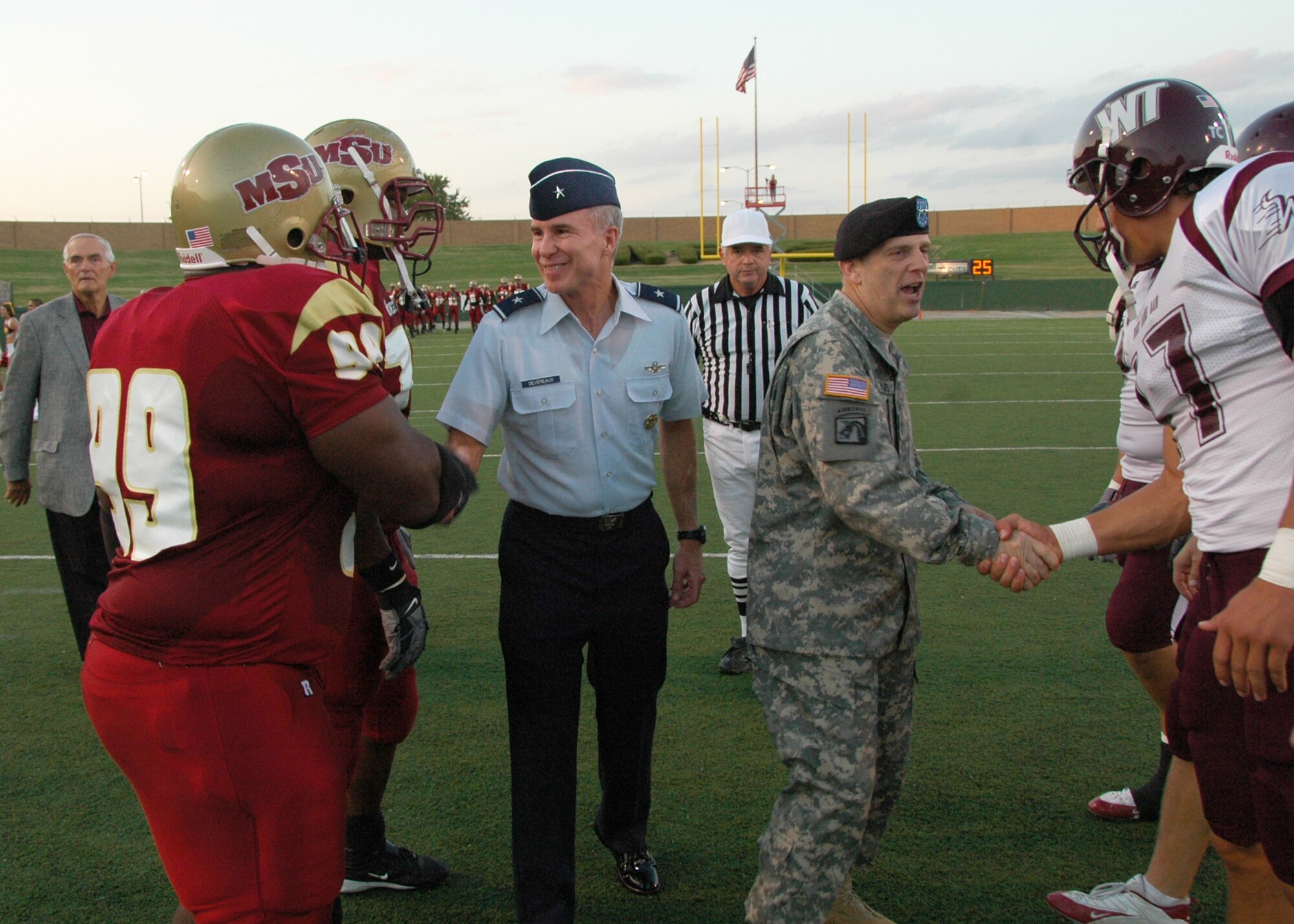 Maj. Gen. Peter Vangjel, right center, commanding general of Ft. Sill, Okla., and Brig. Gen. Richard Devereaux, 82nd Training Wing commander, offer well wishes to football players from Midwestern State University in Wichita Falls and West Texas A&M from Canyon, Texas, before their Oct. 6 football game at Memorial Stadium in Wichita Falls. Both schools took the opportunity to honor the nation's military during the MSU Salute to the Military. Thousands of military members from all services attended the game, including more than 1,500 from Sheppard. (U.S. Air Force photo/Harry Tonemah)
