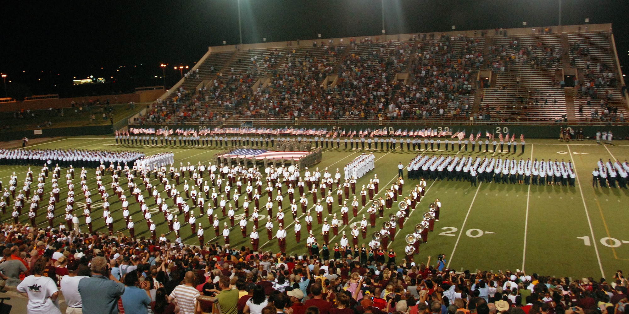 A show of force by the Air Force, Army, Navy and Air Force Junior ROTC cadets join the Midwestern State University Mustangs band during a half time performance at MSU's Salute to the Military Oct. 6 at Memorial Stadium in Wichita Falls, Texas. Thousands of Airmen, Soldiers and Sailors were the honored guest at the annual game set aside by MSU as an opportunity to honor the nation's military services. (U.S. Air Force photo/Mike Litteken)