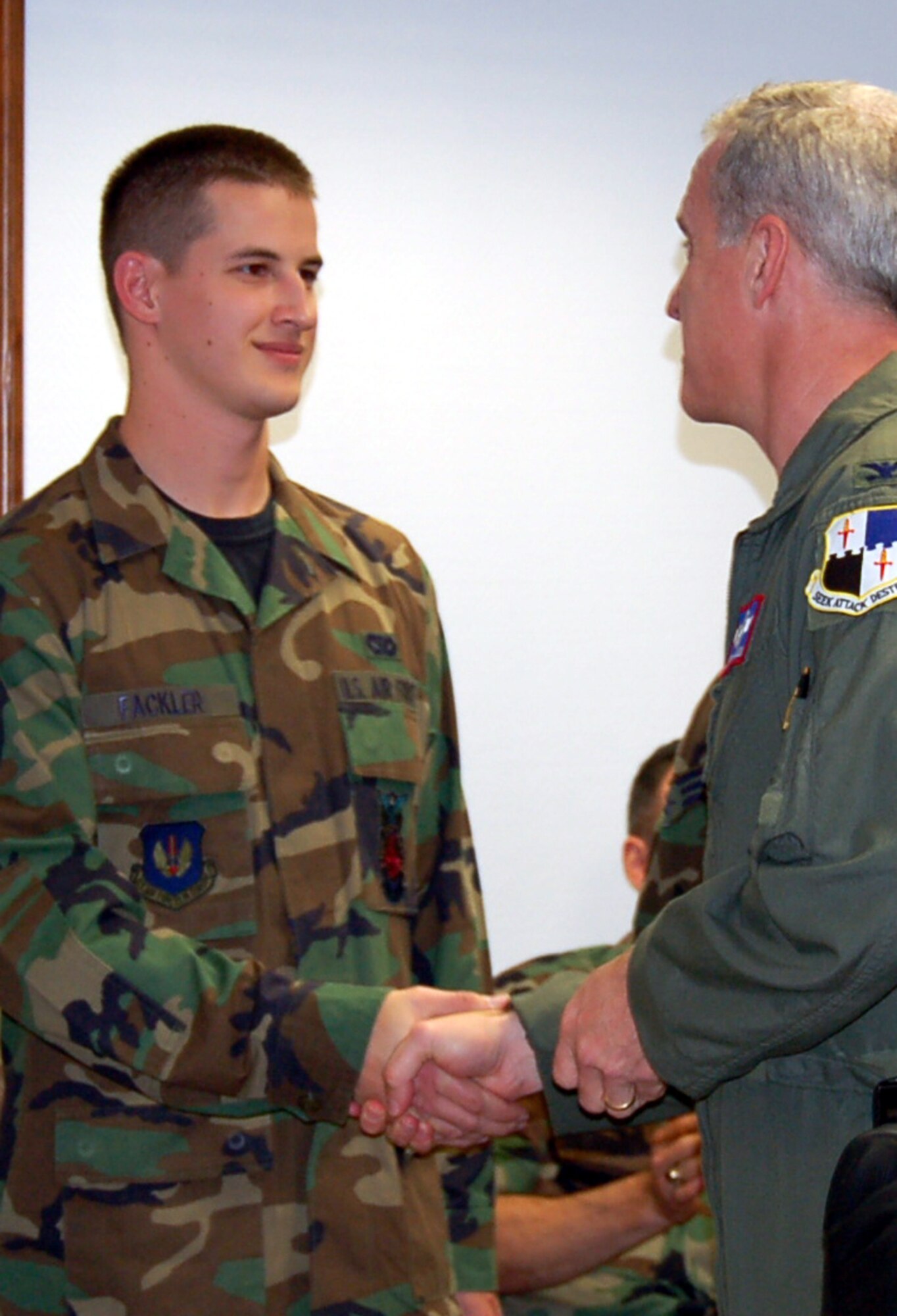 SPANGDAHLEM AIR BASE, Germany – Col. Thomas Feldhausen, 52nd Fighter Wing vice commander, presents Airman 1st Class Jon Fackler, 52nd Civil Engineer Squadron, with a coin for his outstanding score on his career development course exam Oct. 10. (U.S. Air Force photo/Staff Sgt. Tammie Moore)