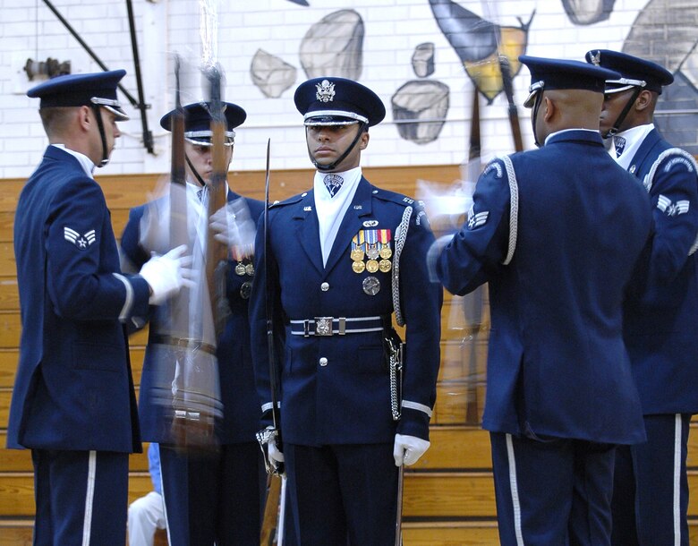 Capt. Joshua Hawkins, of the Air Force Honor Guard Drill Team remains rock steady as other members of the team perform complicated maneuvers with bayonet-tipped rifles during a fantastic drill routine at Etowah High School in Woodstock, Ga. Oct 10. The team was part of a large group of Air Force members, active and reserve, who descended on the school to share their story during Air Force Week Atlanta. Students at Etowah were not only treated to a drill performance, but also to a helicopter landing and a demonstration of tactics from members of the 301st Rescue Squadron, Patrick AFB, Fla. and several static displays. (U.S. Air Force photo/Micah Garbarino)
