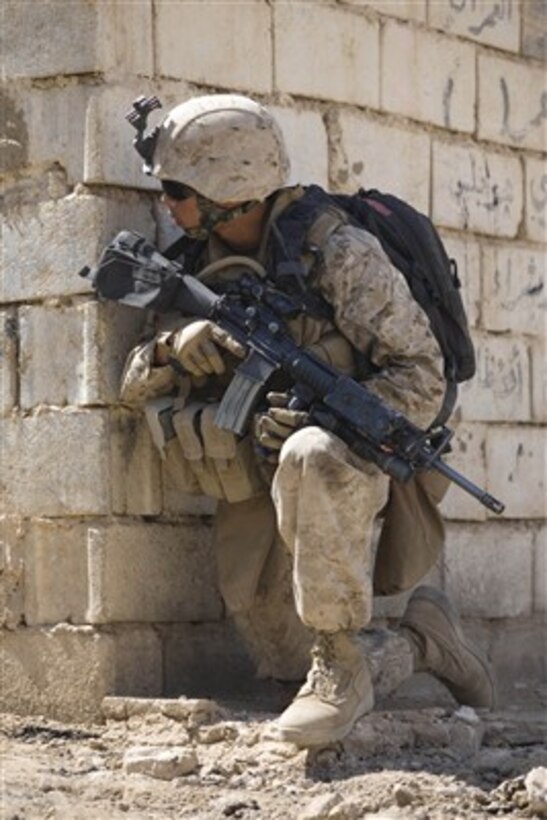 U.S. Marine Corps Pfc. Orlando R. Sudduth peaks around a corner during a patrol halt in Hit, Iraq, on Sept. 20, 2007.  Sudduth is assigned to 2nd Platoon, Charlie Company, 1st Battalion, 7th Marine Regiment.  The Marines are deployed with Multi-National Forces - West in the Al Anbar province of Iraq.  