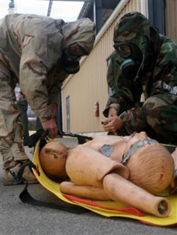 Marine spouses strap a simulated casualty onto a stretcher during Jane Wayne Day here Oct. 11. In a real-world incident, Marines of Chemical Biological Incident Response Force, II Marine Expeditionary Force, use stretchers to extract casualties from collapsed structures.