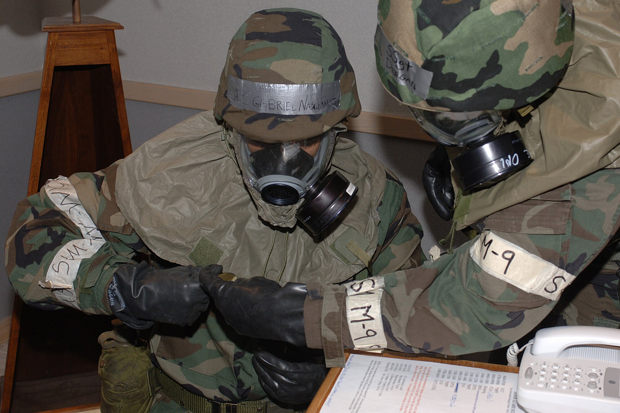 HILL AIR FORCE BASE, Utah-- Airman 1st Class Gabriel Nascimento, 75th Comptroller Squadron, is assisted with his gas mask by Staff Sgt. Shaun Deegan, 75th Mission Support Group during during an operational readiness exercise held here.  This is the first time the 388th Fighter Wing, 419th Fighter Wing and the Ogden ALC have jointly participated in readiness exercises (U.S. Air Force photo by Alex R. Lloyd)