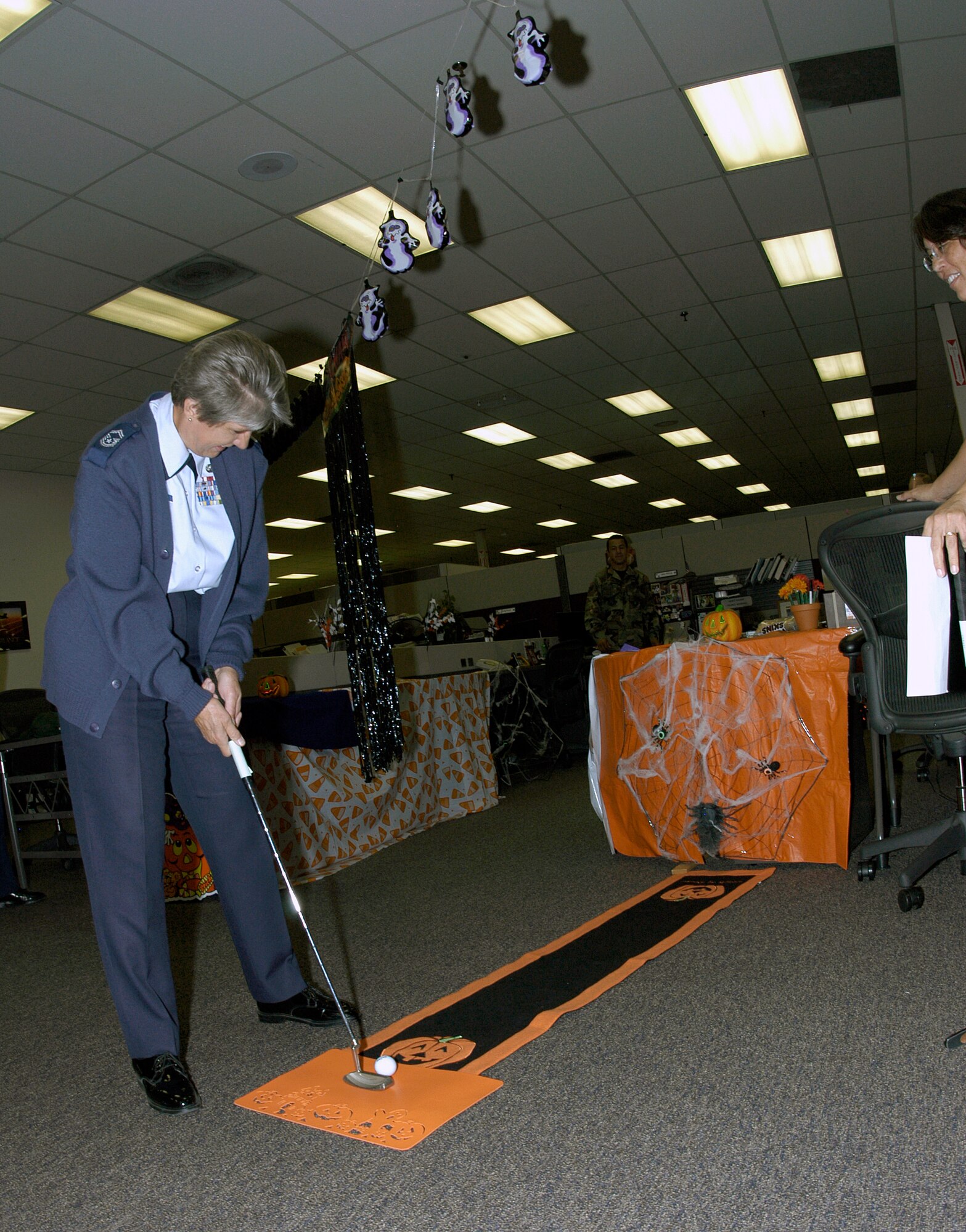 Senior Master Sgt. Melody Mohigh, DPX, takes aim during the second annual Combined Federal Campaign Halloween Putt Putt Golf Tournament at the Air Reserve Personnel Center. The event was held to raise money for the CFC.
