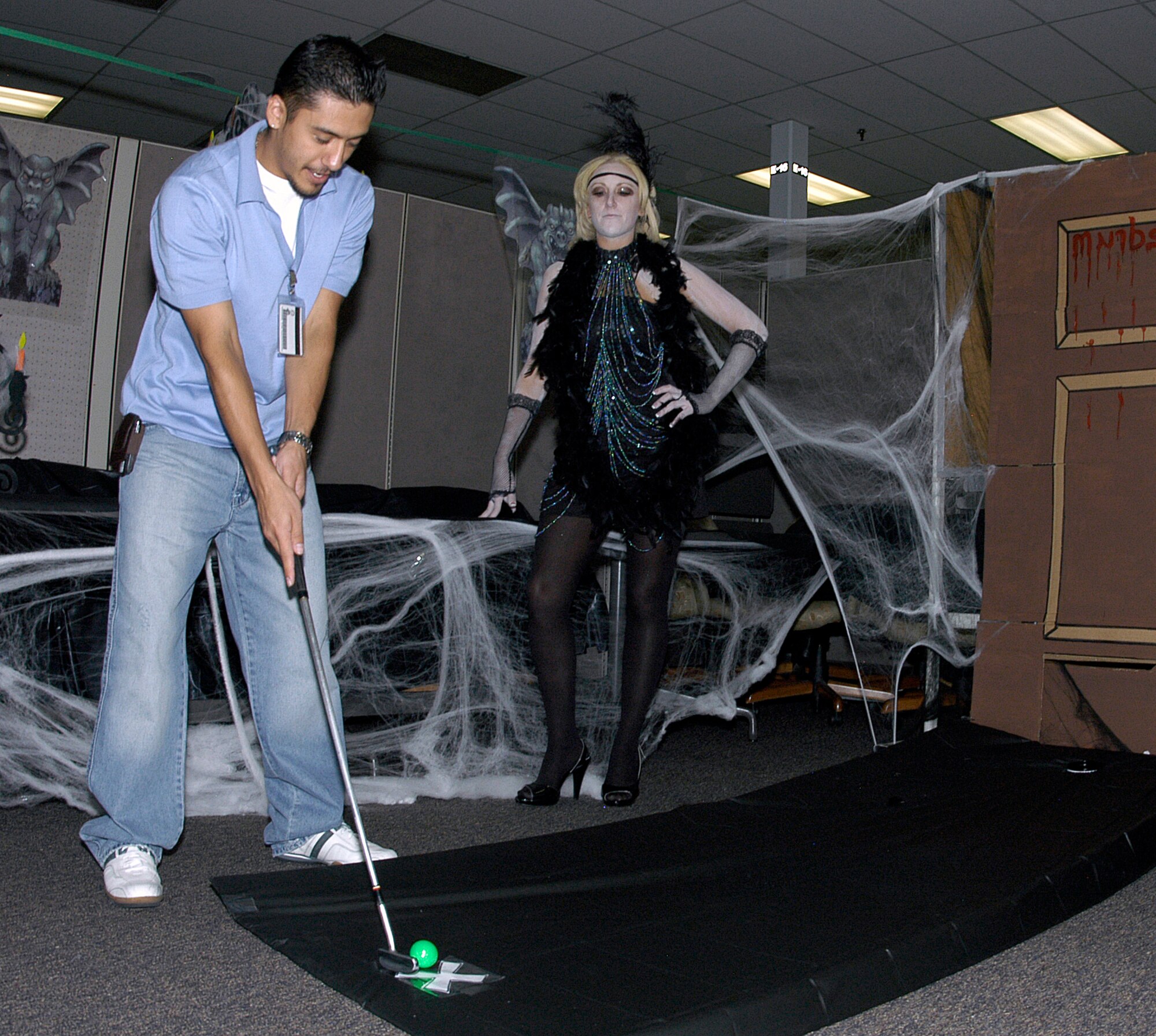 Eric Valdez, PA, takes aim while Danial Menchaca, DPP, looks on. The two  participated in the Combined Federal Campaign Halloween Putt Putt Golf Tournament at ARPC on Oct. 12. 