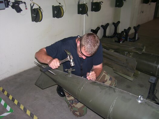 FAIRCHILD AIR FORCE BASE, Wash. – Staff Sgt. Jeremiah Webb, 92nd Maintenance Squadron munitions inspector, etches serial numbers into an inert static MK-82 for static display. The ammo shop is involved in almost every aspect of base operations, from arming security forces Airmen protecting the base to ensuring pilots have proper survival gear for training and mission use. (U.S. Air Force courtesy photo) 
