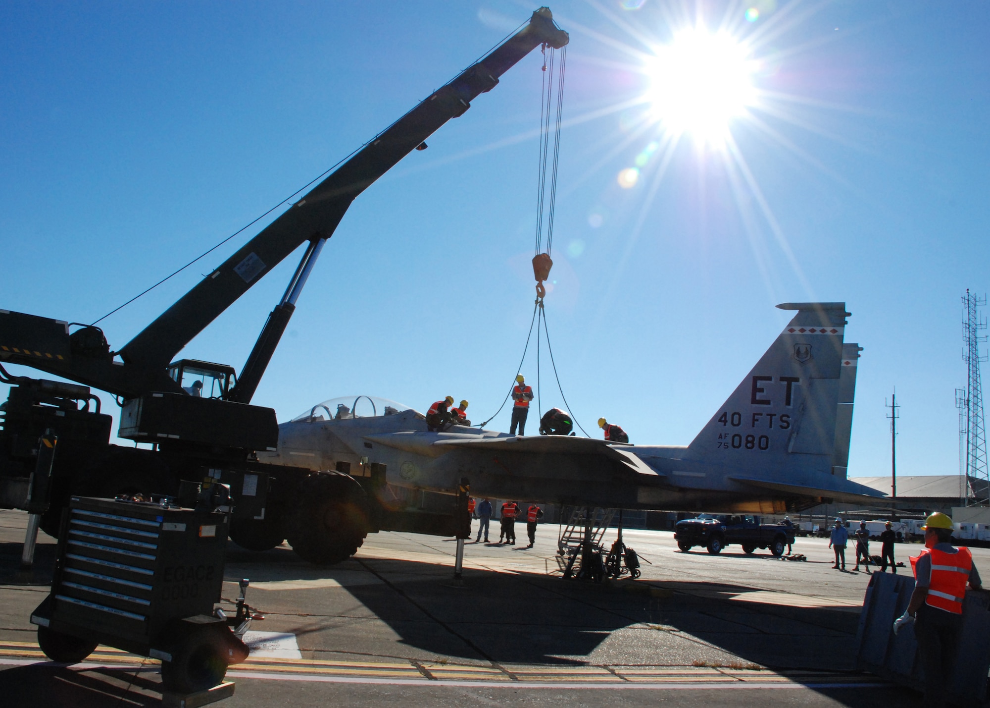 EGLIN AIR FORCE, Fla. -- Members of the 33rd Maintenance Sqaudron help secure the cables to an F-15 to be hoisted by a crane and loaded onto a flatbed trainler for transport Oct. 12. Indyne Inc. U.S. Targets and the 46th Test Wing is moving the F-15 to Range 52 for future testing missions.The crew, lifted the aircraft, collapsed the landing gear and hoisted it onto a flatbed trailer to be transported to Range 52 off Range Road 213. They are scheduled to move the jet beginning at 2 a.m. Oct. 13. (U.S Air Force Photo by Staff Sgt. Mike Meares)
