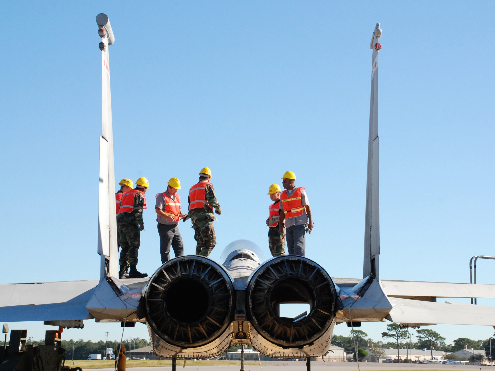 EGLIN AIR FORCE, Fla. -- Members of the 33rd Maintenance Sqaudron help secure the cables to an F-15 to be hoisted by a crane and loaded onto a flatbed trainler for transport Oct. 12. Indyne Inc. U.S. Targets and the 46th Test Wing is moving the F-15 to Range 52 for future testing missions.The crew, lifted the aircraft, collapsed the landing gear and hoisted it onto a flatbed trailer to be transported to Range 52 off Range Road 213. They are scheduled to move the jet beginning at 2 a.m. Oct. 13. (U.S Air Force Photo by Staff Sgt. Mike Meares)