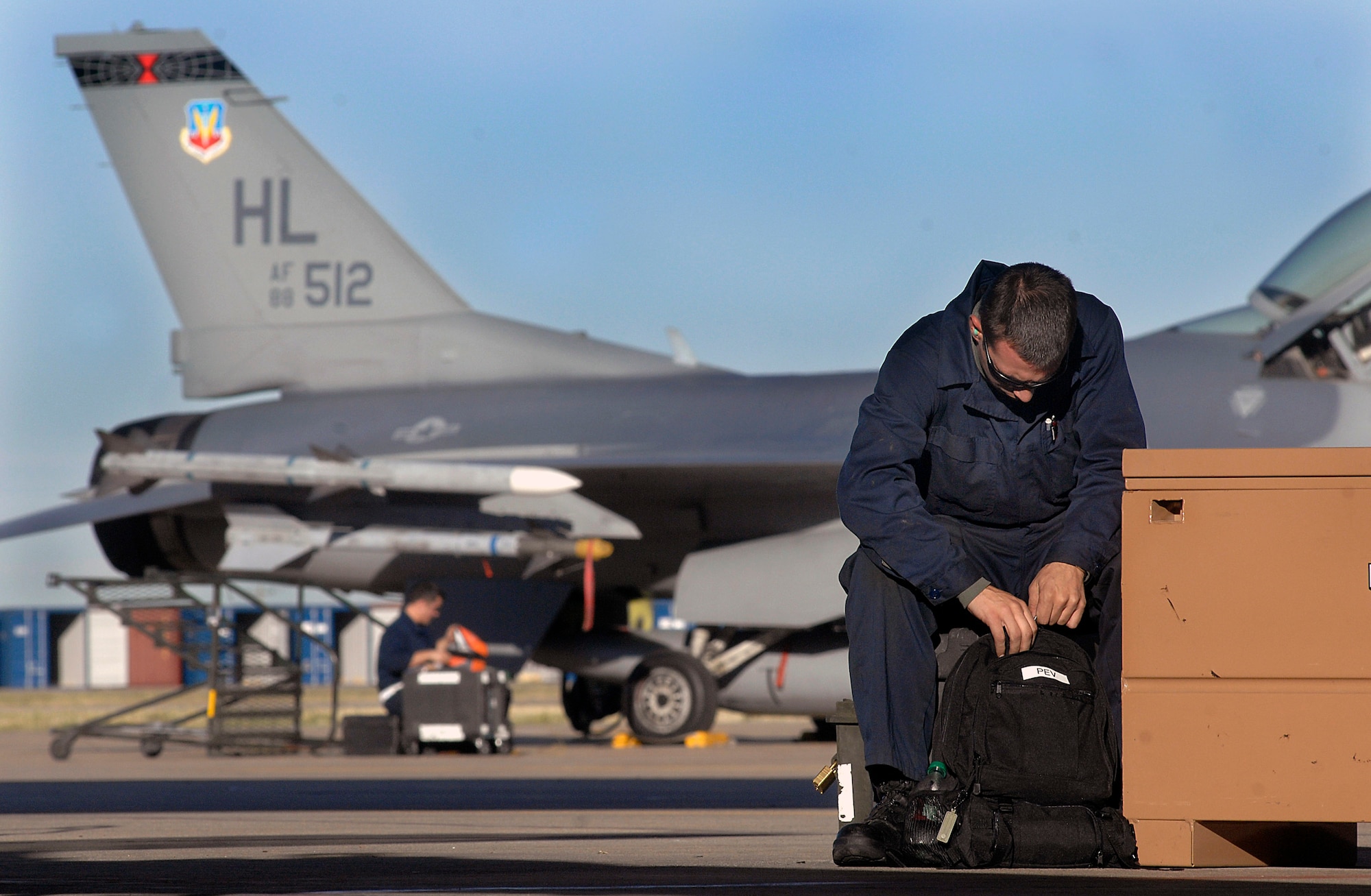 Senior Airman Robert Pevoroff gets ready to prep an F-16 Fighting Falcon for flight Oct. 10 while Staff Sgt. Chris Hatten reviews forms prior to the arrival of the aircrew.  Both crew chiefs are assinged at Hill Air Force Base, Utah., Sergeant Hatten is with the 388th Aircraft Maintenance Squadron and Airman Pevoroff is with the 421st Aircraft Maintenance Squadron. (U.S. Air Force photo/Tech. Sgt. Larry A. Simmons)