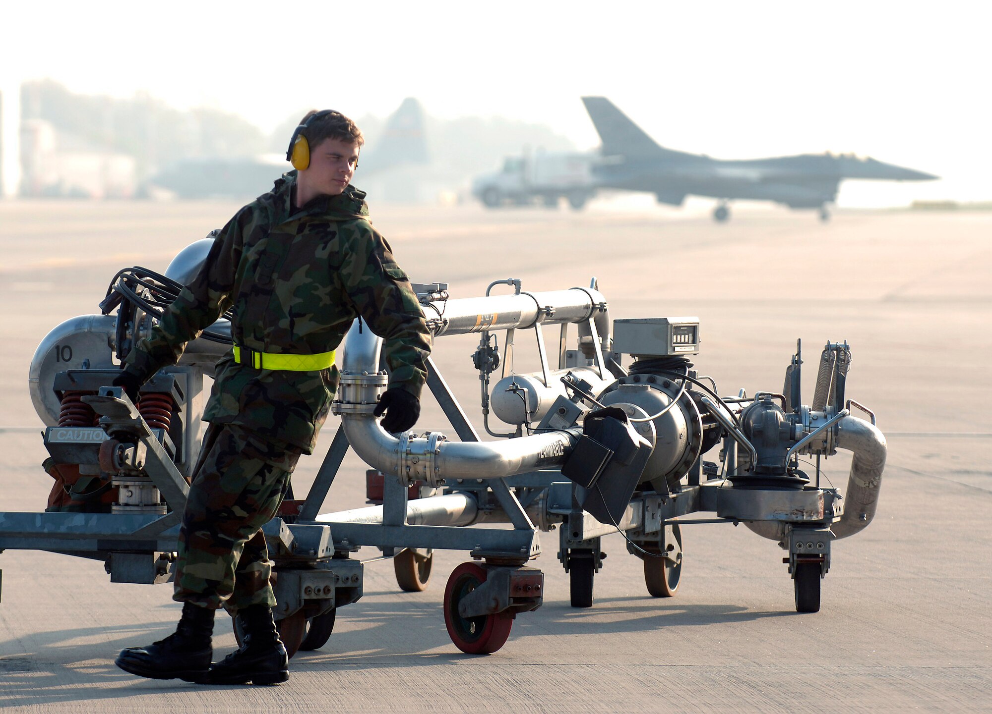 Airman 1st Class Jesse Hayes moves a pipe system, known as a pantograph, into place before pumping JP-8 fuel into a C-17 Globemaster III at Ramstein Air Base, Germany, Oct. 11. Airman Hayes is a mobile fuels operator assigned to the 435th Logistics Readiness Squadron. (U.S. Air Force photo/Master Sgt. Scott Wagers)