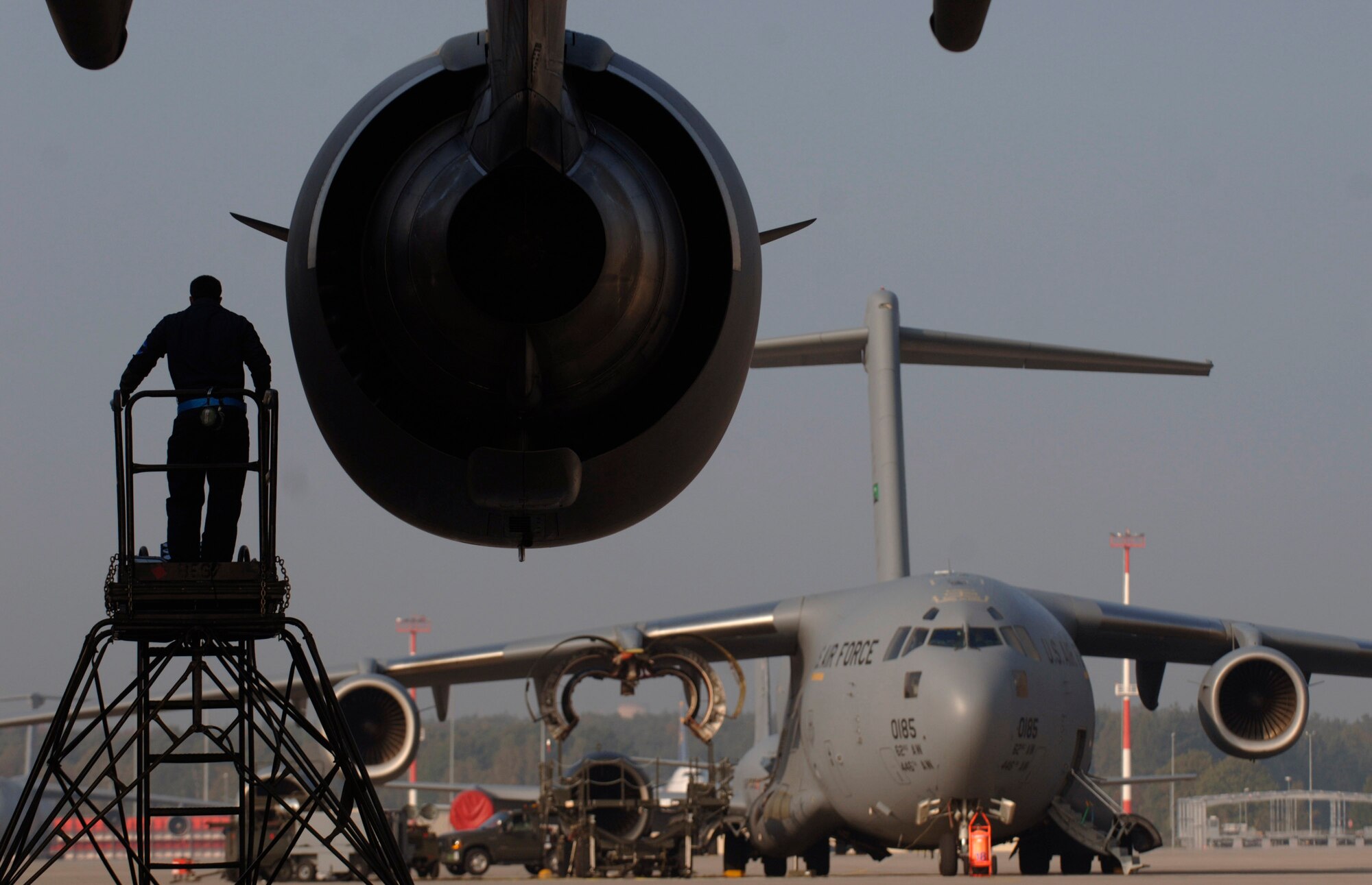 Senior Airman Lance Sithammalat climbs down a ladder after adding the last of 17 quarts of synthetic oil to a C-17 Globemaster III at Ramstein Air Base, Germany, Oct. 11. Airman Sithammalat is a crew chief assigned to the 723rd Air Mobility Squadron. (U.S. Air Force photo/Master Sgt. Scott Wagers)
