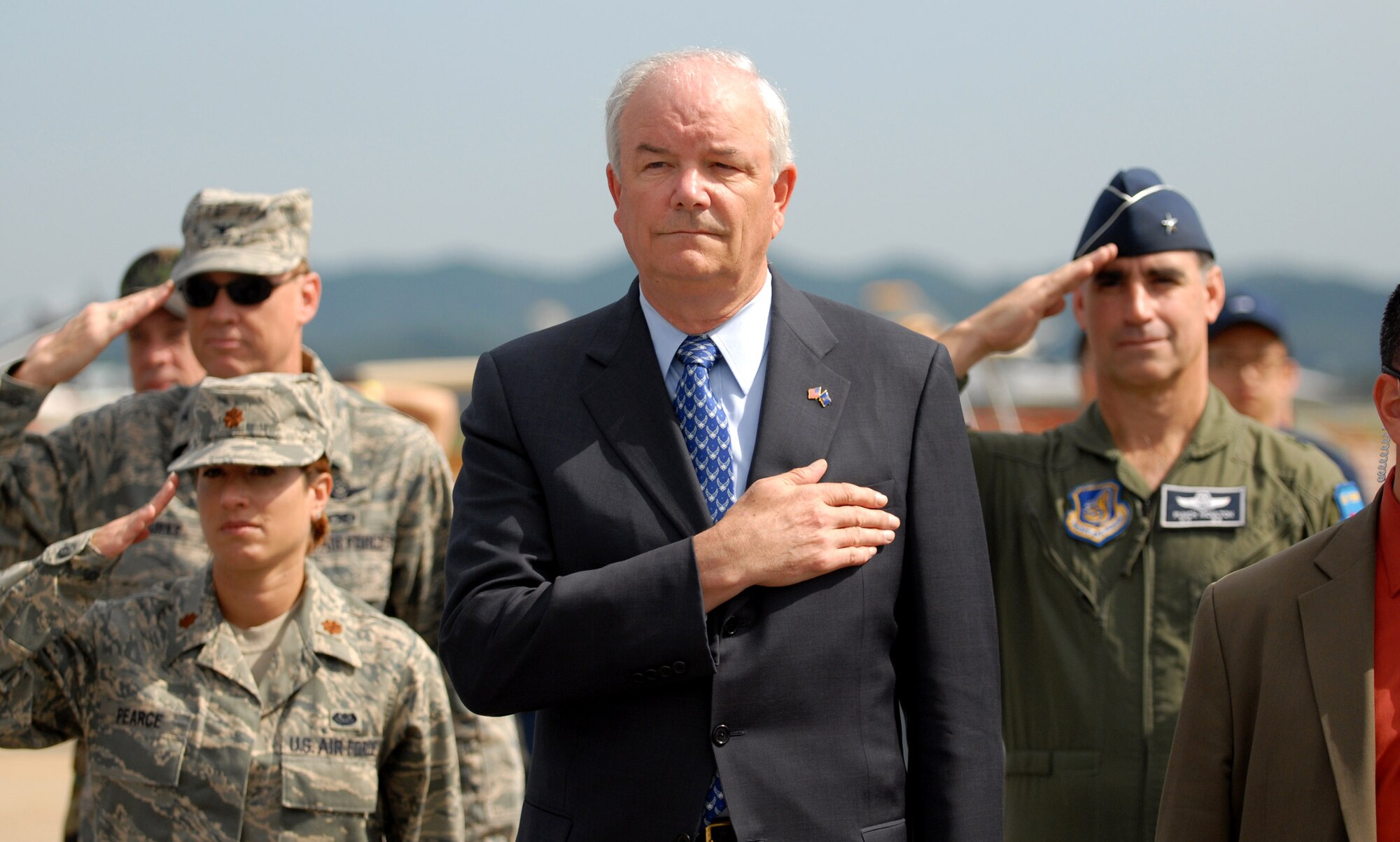 Secretary of the Air Force Michael W. Wynne, along with Col. Darryl Burke, Maj. Michelle Pearce and Brig. Gen. Harold W. "Punch" Moulton II, stands for the national anthem during opening ceremonies for Air Power Day Oct. 6 at Osan Air Base, South Korea. (U.S. Air Force photo/1st Lt. John Ross) 