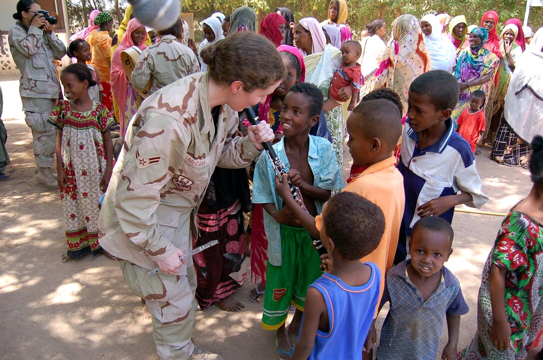 Airman 1st Class Amy McCann meets local children in Damerjog village, Djibouti, Oct. 9. Airman McCann and other members of the U.S. Central Command Air Forces Celtic Band performed a 45-minute show and handed out gifts and toys as part of a community relations event. This is the fist time the CENTAF Celtic Band has deployed. Other members of the band are Tech. Sgts. Sherry Burt and Gail Adams, Staff Sgt. Lacey Stokes and Airman 1st Class Brandon Richard. (U.S. Air Force photo) 