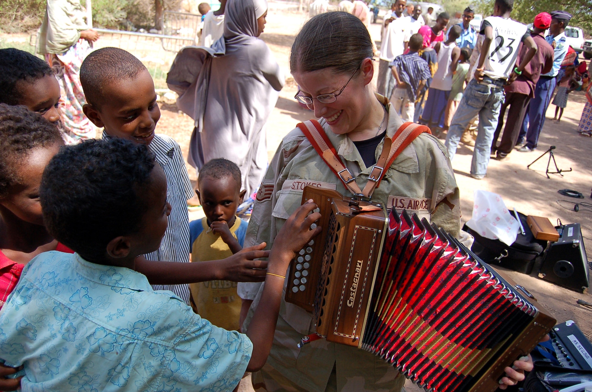Staff Sgt. Lacey Stokes meets local children in Damerjog village, Djibouti, Oct. 9. Sergeant Stokes and other members of the U.S. Central Command Air Forces Celtic Band performed a 45-minute show and handed out gifts and toys as part of a community relations event. This is the fist time the CENTAF Celtic Band has deployed. Other members of the band are Tech. Sgts. Sherry Burt and Gail Adams, and Airmen 1st Class Brandon Richard and Amy McCann. (U.S. Air Force photo)