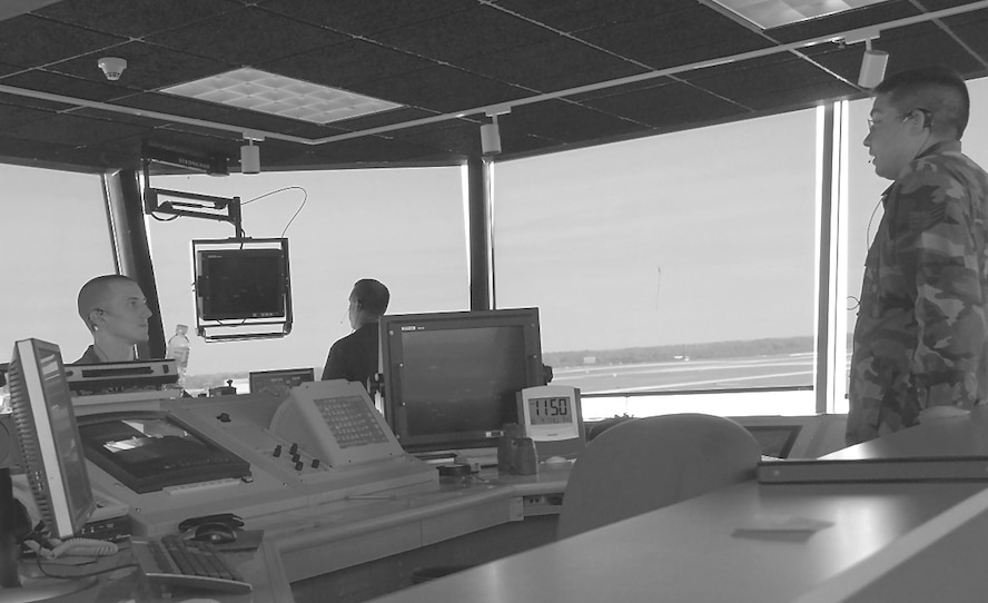 Airman 1st Class Jason Henre consults with Staff Sgt. Peter Salzano in the Wright-Patterson Air Force Base control tower.  (Skywrighter photo by Christy Webb)