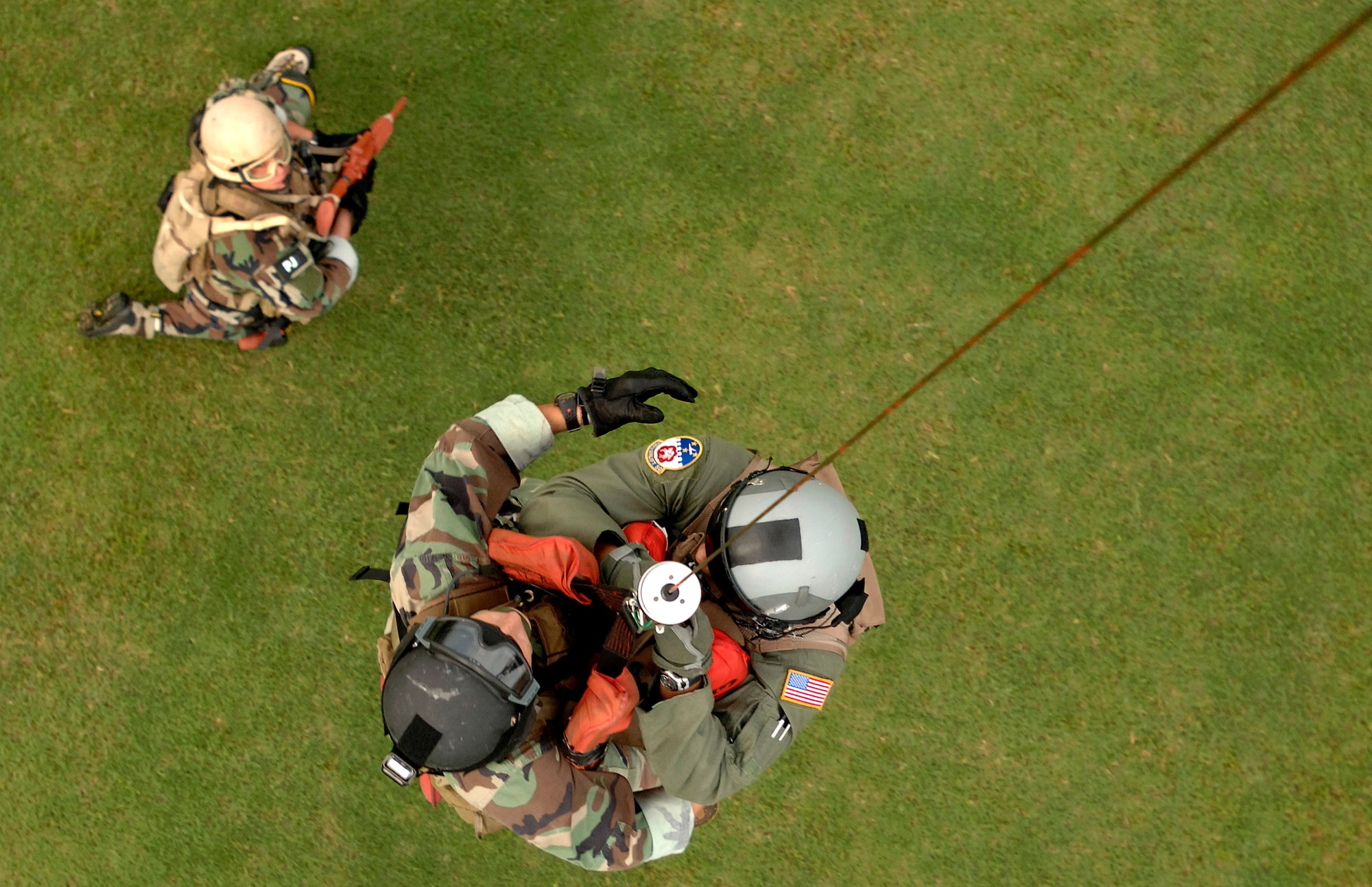 Master Sgt. John Shiman (left) watches fellow pararescuemen Senior Airmen Rich Boyd hoist a downed pilot into a hovering HH-60G Pave Hawk helicopter. The simulated rescue was conducted during an Air Force Week Atlanta event Oct. 9 at Marietta High School in Marietta, Ga. The event helped to educate students about the U.S. Air Force. (U.S. Air Force photo/Staff Sgt. Bennie J. Davis III) 