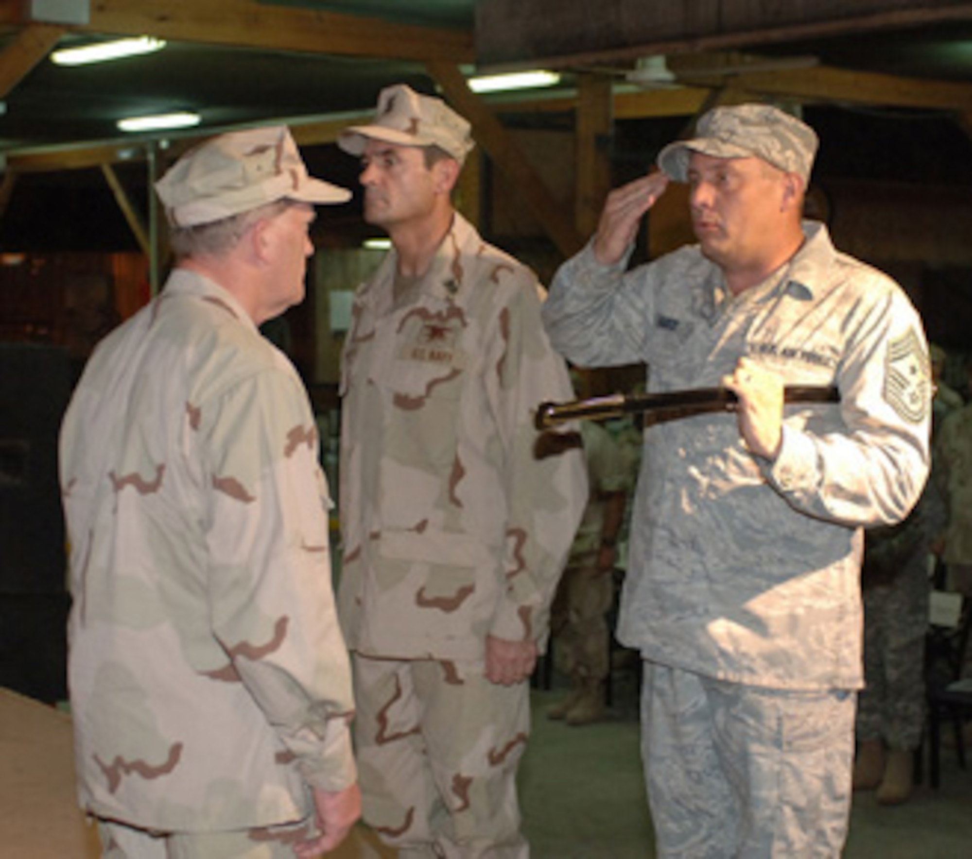 CAMP LEMONIER, Djibouti -- Chief Master Sgt. John R. Harris Jr., outgoing senior enlisted advisor for Combined Joint Task Force-Horn of Africa, salutes Rear Adm. James Hart, CJTF-HOA commander, during a Relief and Appointment Ceremony at Camp Lemonier's New Cantina Sept. 29. The ceremony marked the end to Harris' 13-month tour as HOA's senior enlisted leader and featured the passing of the sword, which represents the turnover of senior enlisted responsibilities from Harris to Navy Command Master Chief Roy Maddocks. U.S. Navy photo by Mass Communication Specialist 1st Class Mary Popejoy (RELEASED)