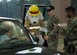 Sparky the Fire Dog hands out candy while Staff Sgt. Nathaniel Reed, 316th Civil Engineer Squadron, and Senior Airman Nicholas West, 316th Security Forces Squadron, hand out pamphlets and check IDs at the Andrews Air Force Base main gate Oct. 9.