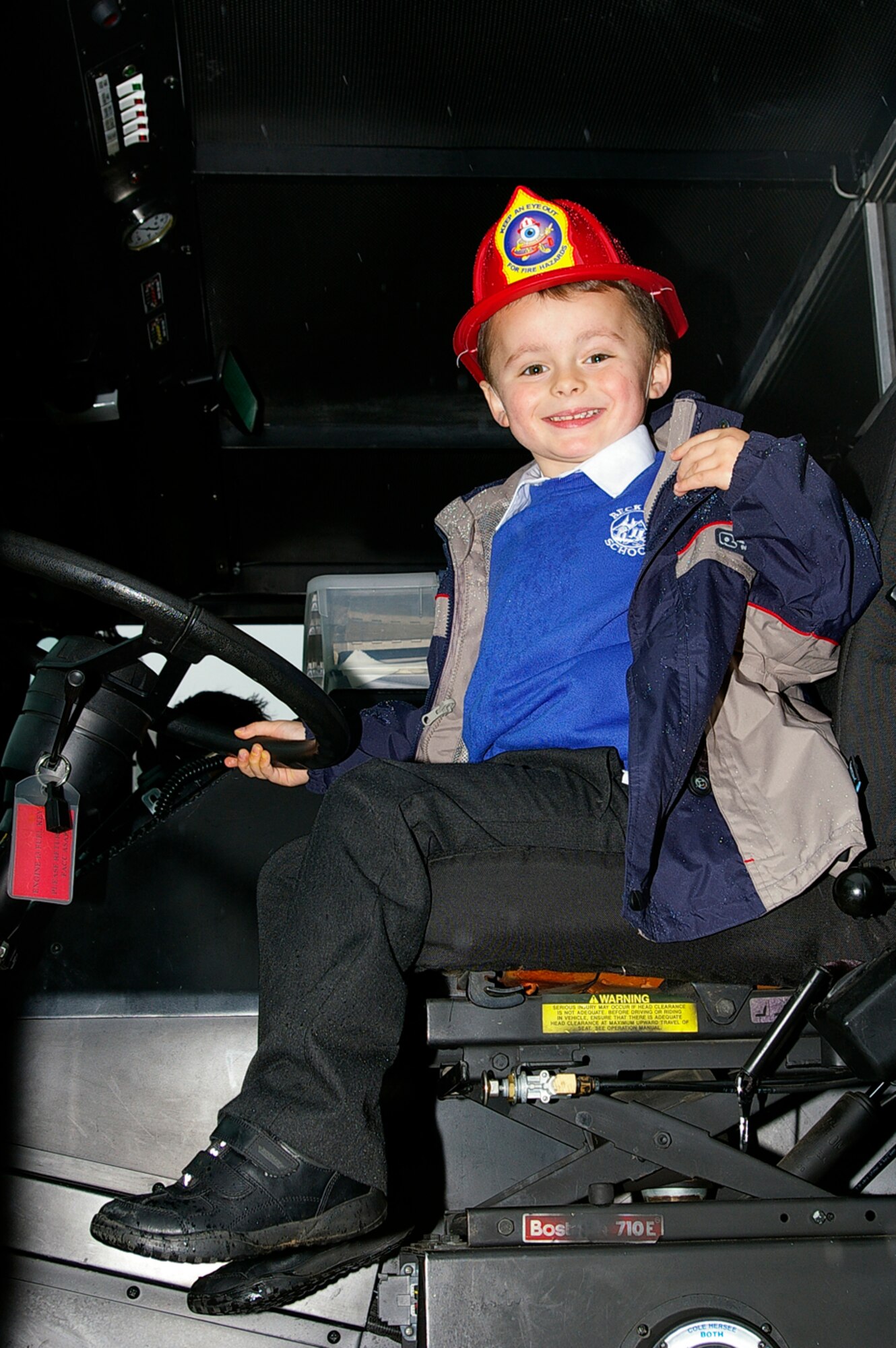 Jackson Sullivan, 4, from France Class at Beck Row Primary School, checks out the driver's seat of a fire truck from the RAF Mildenhall Fire Department Oct. 9. Sparky the Fire Dog and two firefighters from RAF Mildenhall visited the primary school as part of Fire Prevention Week activities. (U.S. Air Force photo by Karen Abeyasekere)