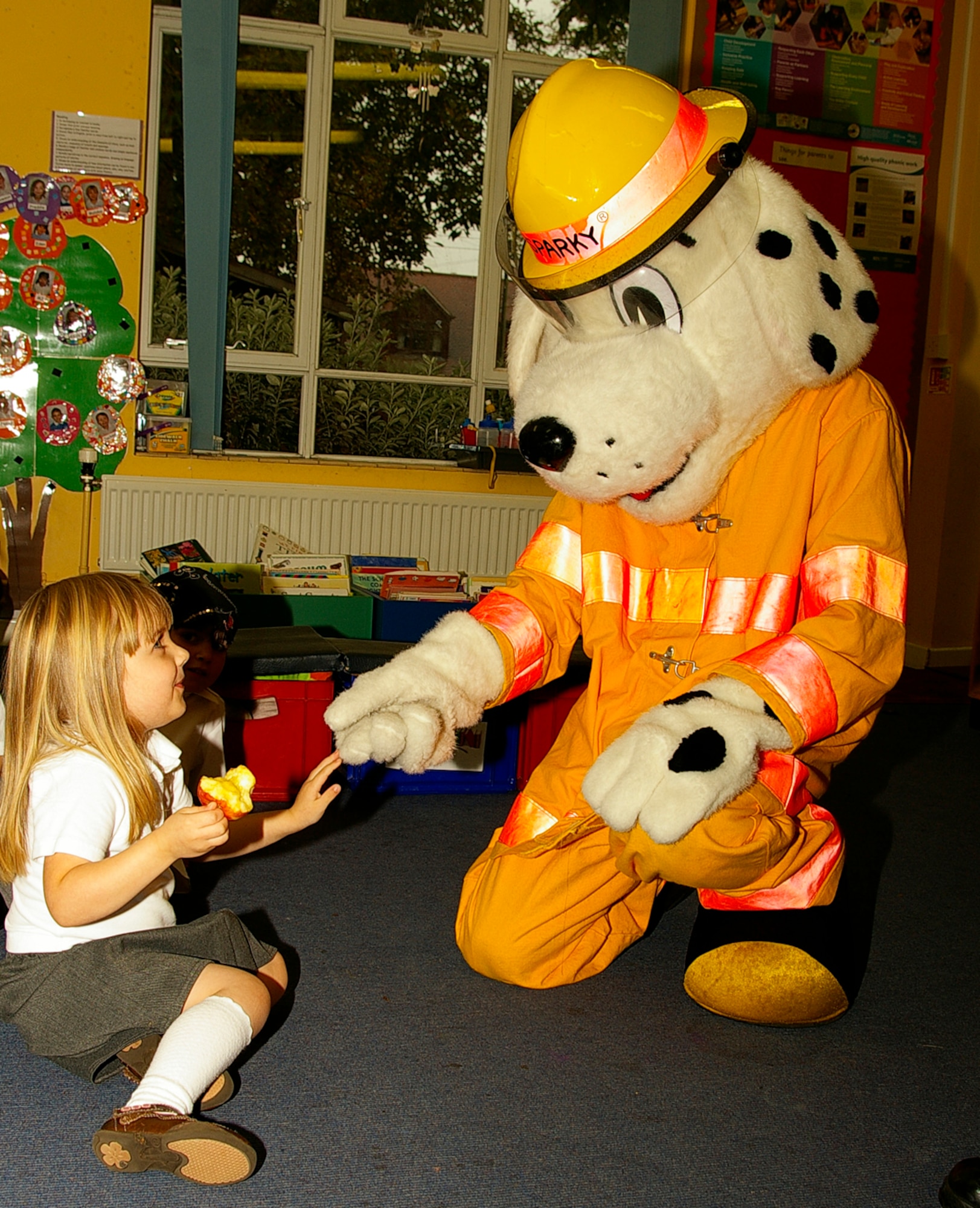 Megan McCrea, 4, greets Sparky the Fire Dog during a visit to France Class at Beck Row Primary School Oct. 9, as part of Fire Prevention Week. (U.S. Air Force photo by Karen Abeyasekere)