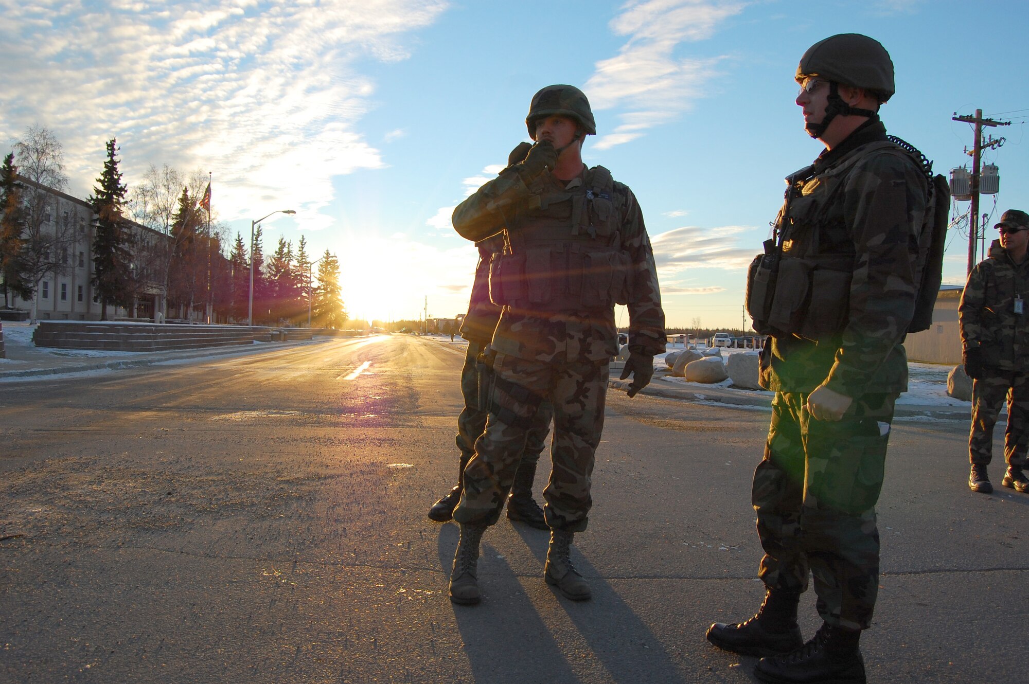 EIELSON AIR FORCE BASE, Alaska --  Staff Sgt. Justin Buchholz, 354th Security Forces Squadron, checks in over a radio as Maj. Gerald Mulhollen, 354th Security Forces Squadron, scans the surrounding area during a simulated bomb threat on Amber Hall Oct. 12, 2007. Eielson perfeormed an Operational Readiness Exercise Oct. 11 to 14, which contained a variety of scenarios and is employed to ensure Airmen are ready to mobilize at a moments notice when its nation calls. (U.S. Air Force photo by Airman 1st Class Christopher Griffin)