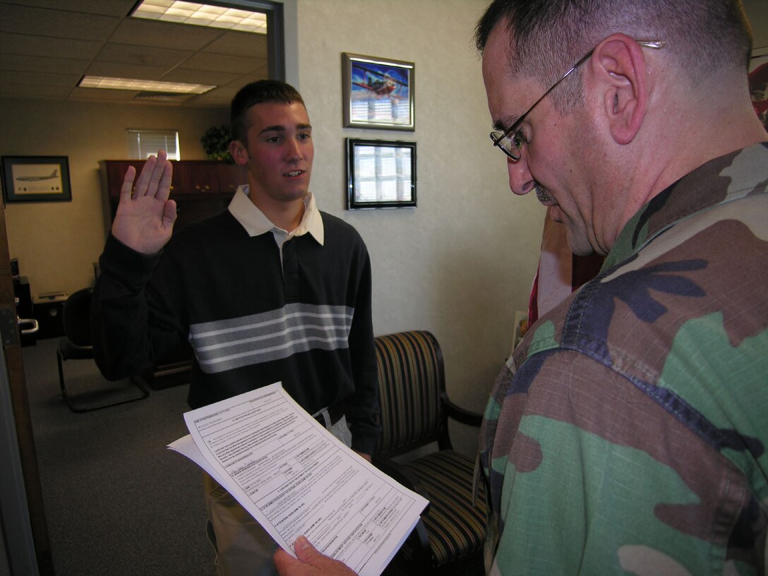 SEYMOUR JOHNSON AIR FORCE BASE, N.C.--Maj. Donald McCauley enlists his son, Collin, into the Air Force Reserve on Oct. 13, 2007. Maj. McCauley is a member of the 916th Air Refueling Wing Aerospace Medicine Flight and serves as a physician's assistant. Collin will be joining the tanker wing as a Security Forces specialist after completing his basic training and technical schools at Lackland Air Force Base, Texas.