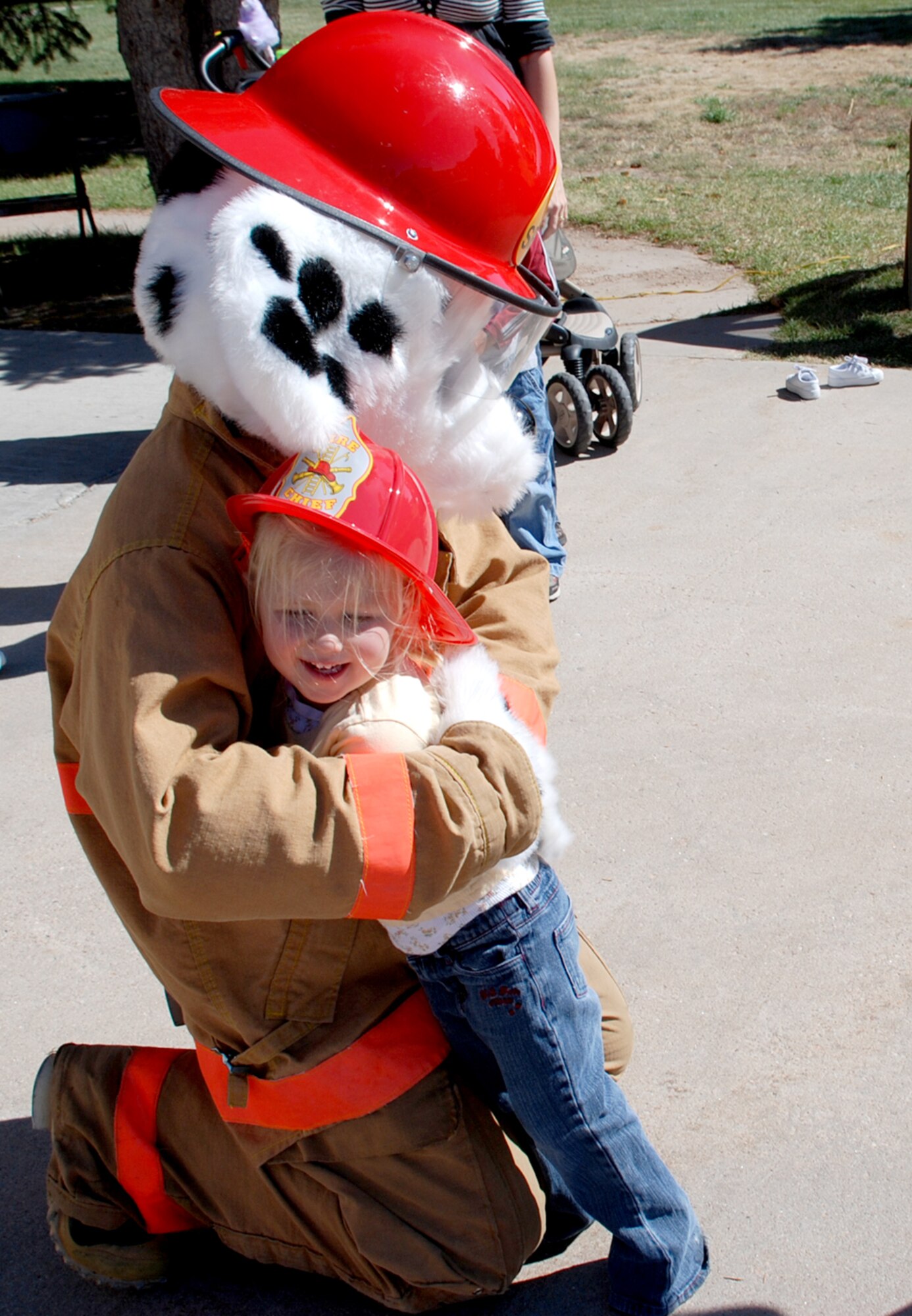 Camdyn Iles hugs Sparky, Airman 1st Class Andrew Kose, Saturday at the fire prevention week open house. Sparky is the mascot for the Warren Fire Department.