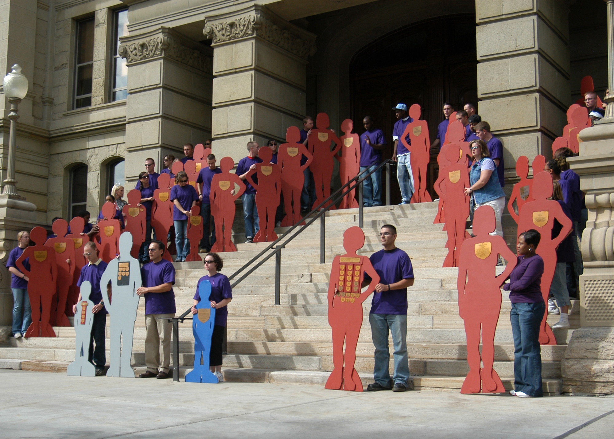 Thirty-seven Warren Airmen, civilians and family members assemble Oct. 5 at the steps of Cheyenne capital building to support “the silent witness march.” The march went from the Cheyenne courthouse to the capital for October’s Domestic Violence Month. Each participant wore a purple shirt and carried a victim of domestic violence. The event’s purpose was to teach people that if they are a witness of domestic violence they shouldn’t be afraid to speak up (Photo by Shelley Raffl).