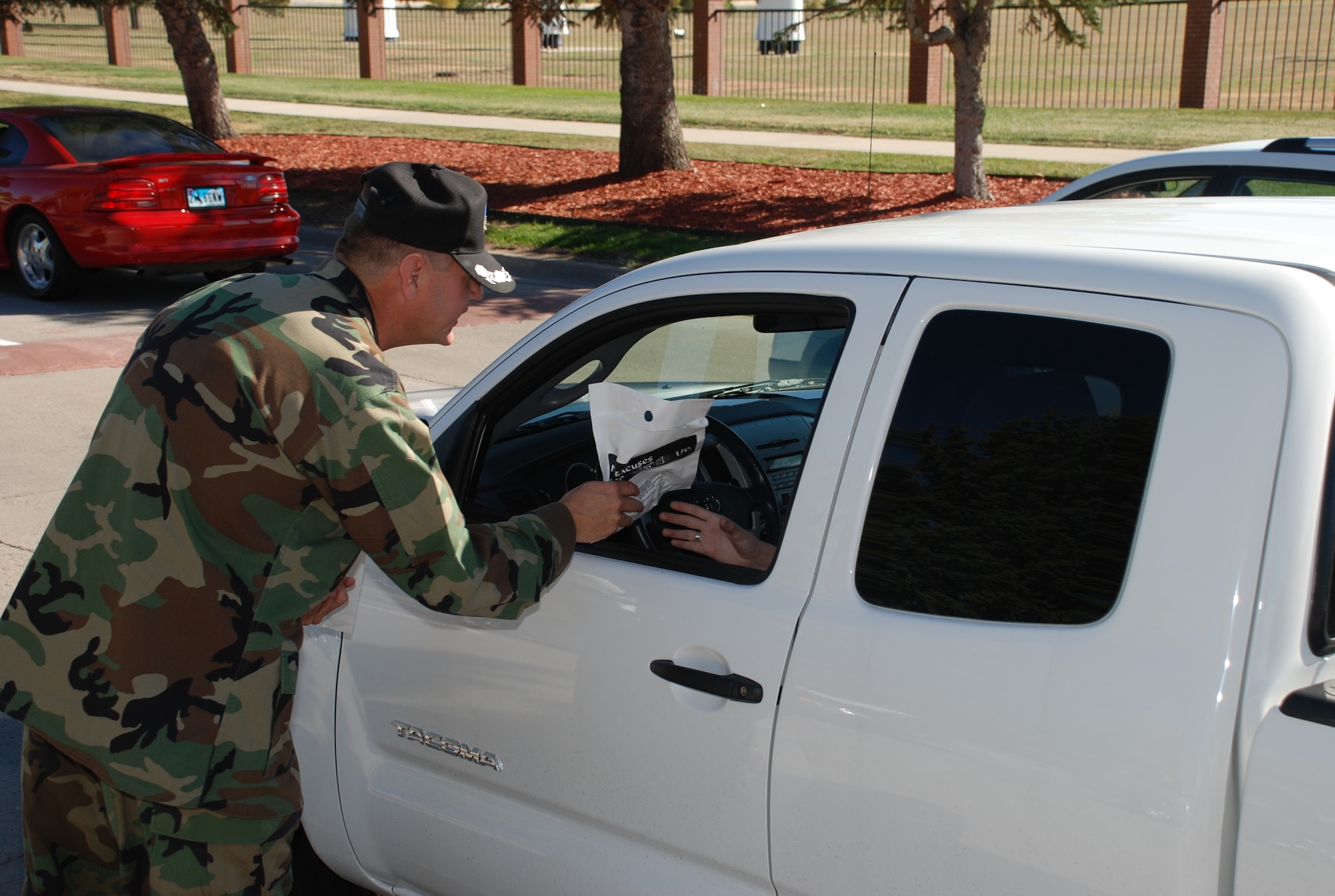 Col. L.B. Mobley, 90th Maintenance Group commander, hands out goodies Oct. 5 at Warren’s Gate 1 with the message to “be safe this weekend.”  Warren’s leadership wanted to ensure Airmen remain safe during the four-day Columbus Day weekend by handing out 200 bags filled with little reminders to buckle-up, don’t drink and drive and follow 0-0-1-3 (Photo by Staff Sgt. Chad Thompson).
