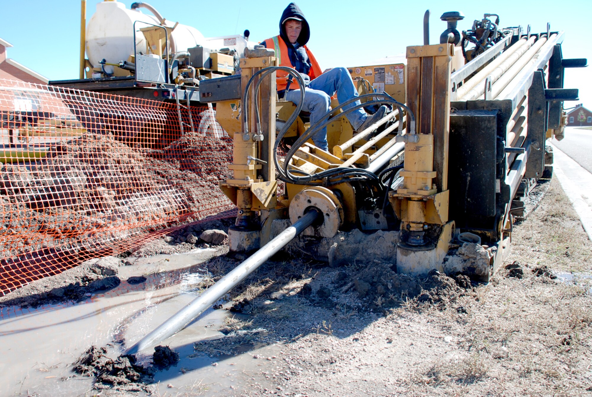 Travis Speed, Temple Construction, operates a directional boring machine here Oct. 2. The machine has a duckbill-shaped drill and has the capability of drilling above or around utilities placed in the ground. The construction company started replacing steel gas lines in April (Photo by Airman 1st Class Daryl Knee).
