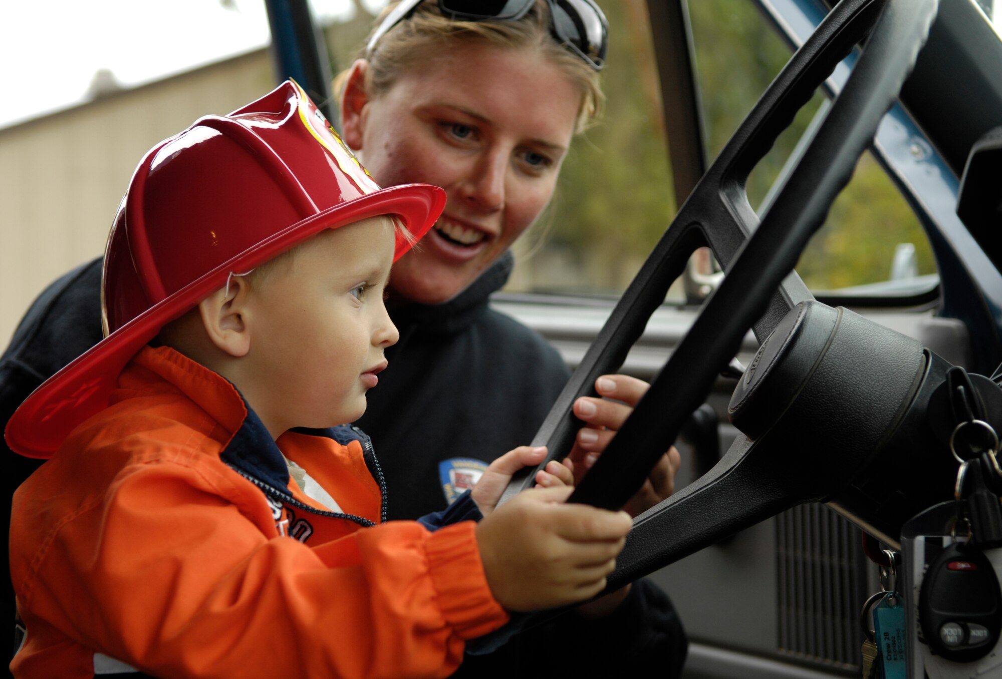 VANDENBERG AIR FORCE BASE, Calif.--Kristin Halbeisen, Vandenberg Hot Shots Firefighter, lets two year old Adan Reedy sit inside of a fire truck on Oct. 12.  The Hot Shots make an annual visit to the Child Development Center during fire prevention week. (U.S. Air Force photo/Airman 1st Class Cole Presley)
