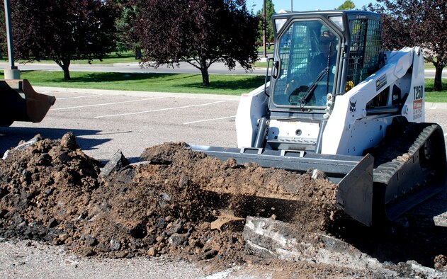 David Simpson, 90th Civil Engineer Squadron, operates a heavy machine in the Burger King parking lot. The 90th CES horizontal flight is redoing the parking lot because of the potholes and the instability underneath the pavement (Photo by Airman 1st Class Daryl Knee).