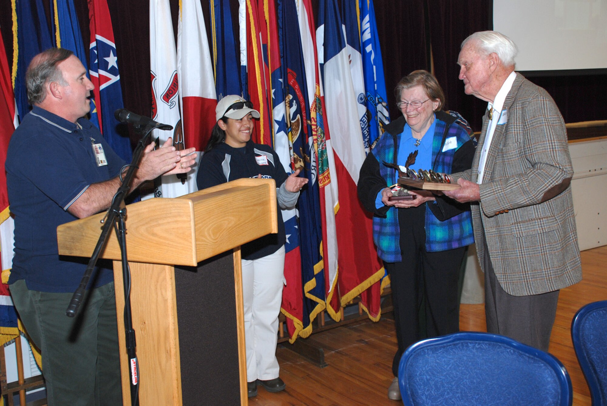 Kerry Glaser, 90th Force Support Squadron, and Staff Sgt. Marissa Morrison, 90th FSS, honors Army Col. (Ret.) Marshell McBee and his wife, Anna McBee, as being the oldest retirees at the Retiree Appreciation Day and Informational Fair Sept. 29.