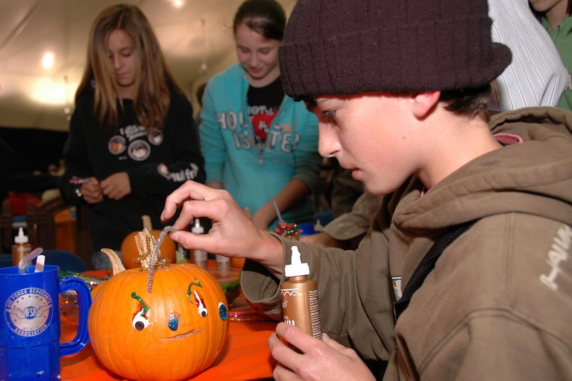HANSCOM AFB, Mass. – Base youth decorate pumpkins at one of the Oktoberfest craft tables. Other children’s activities included face painting, sumo wrestling and the popular Bouncy Castle. (U.S. Air Force photo by Dennis Lewis)