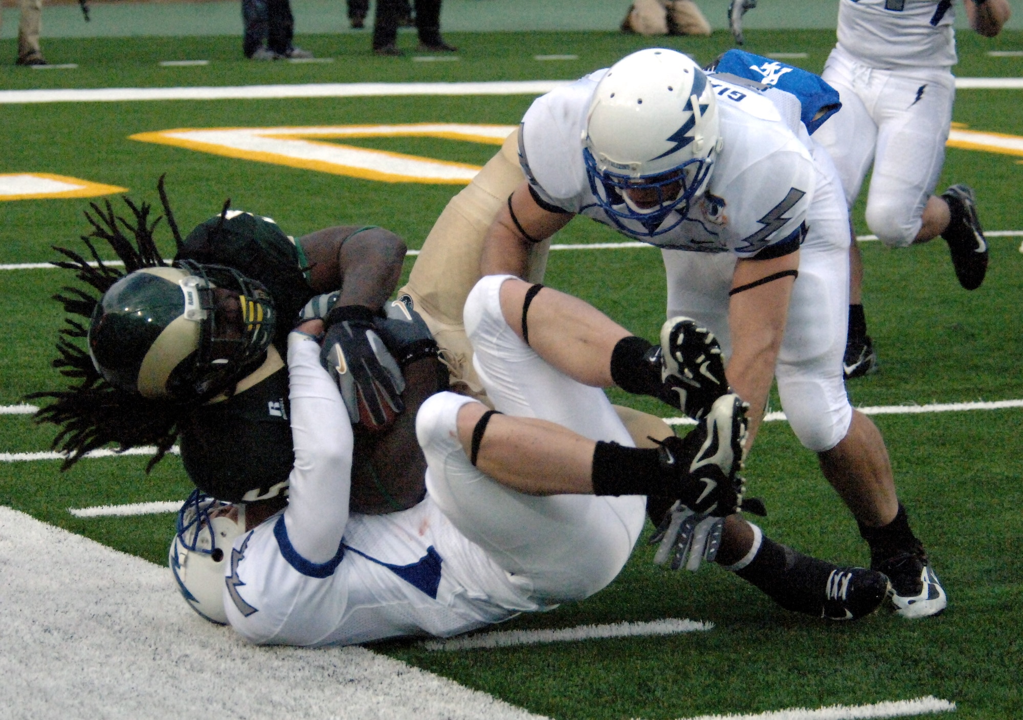 Falcon cornerback Carson Bird wraps up Colorado State running back Gartrell Johnson as safety Bobby Giannini close in during Air Force's 45-21 victory over the Rams Oct. 13 in Fort Collins, Colo. The two senior secondary veterans combined for 13 tackles, including nine solos. (U.S. Air Force photo/John Van Winkle)