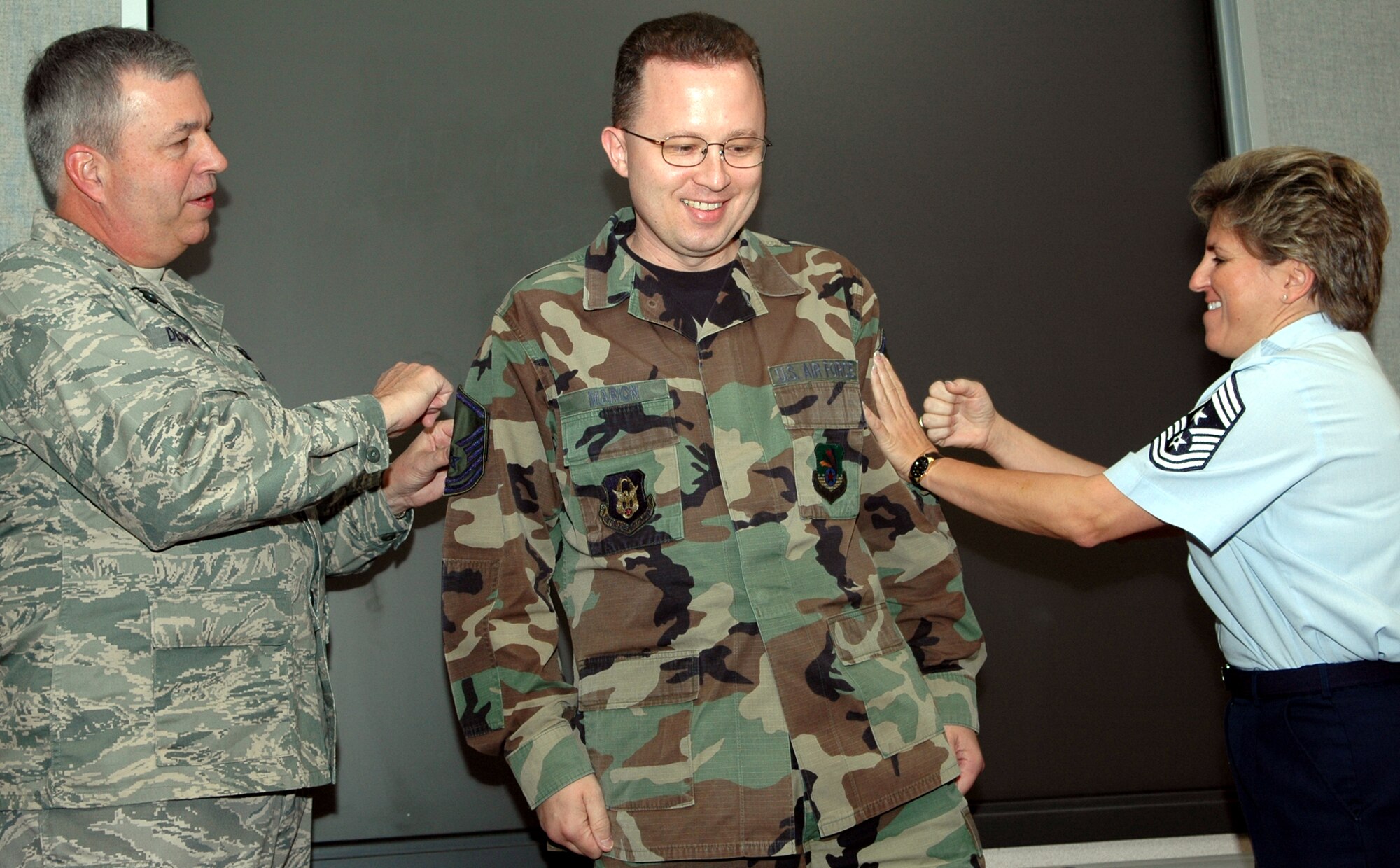 GRISSOM AIR RESERVE BASE, Ind, -- Wesley Marion, center, a paralegal technician with the 434th Air Refueling Wing, has his new master sergeant stripes tacked on by Brig. Dean Despinoy, 434th ARW commander, and Chief Master Sgt. Peri Rogowski, command chief, during a wing staff meeting. (U.S. Air Force photo/SrA. Chris Bolen)
