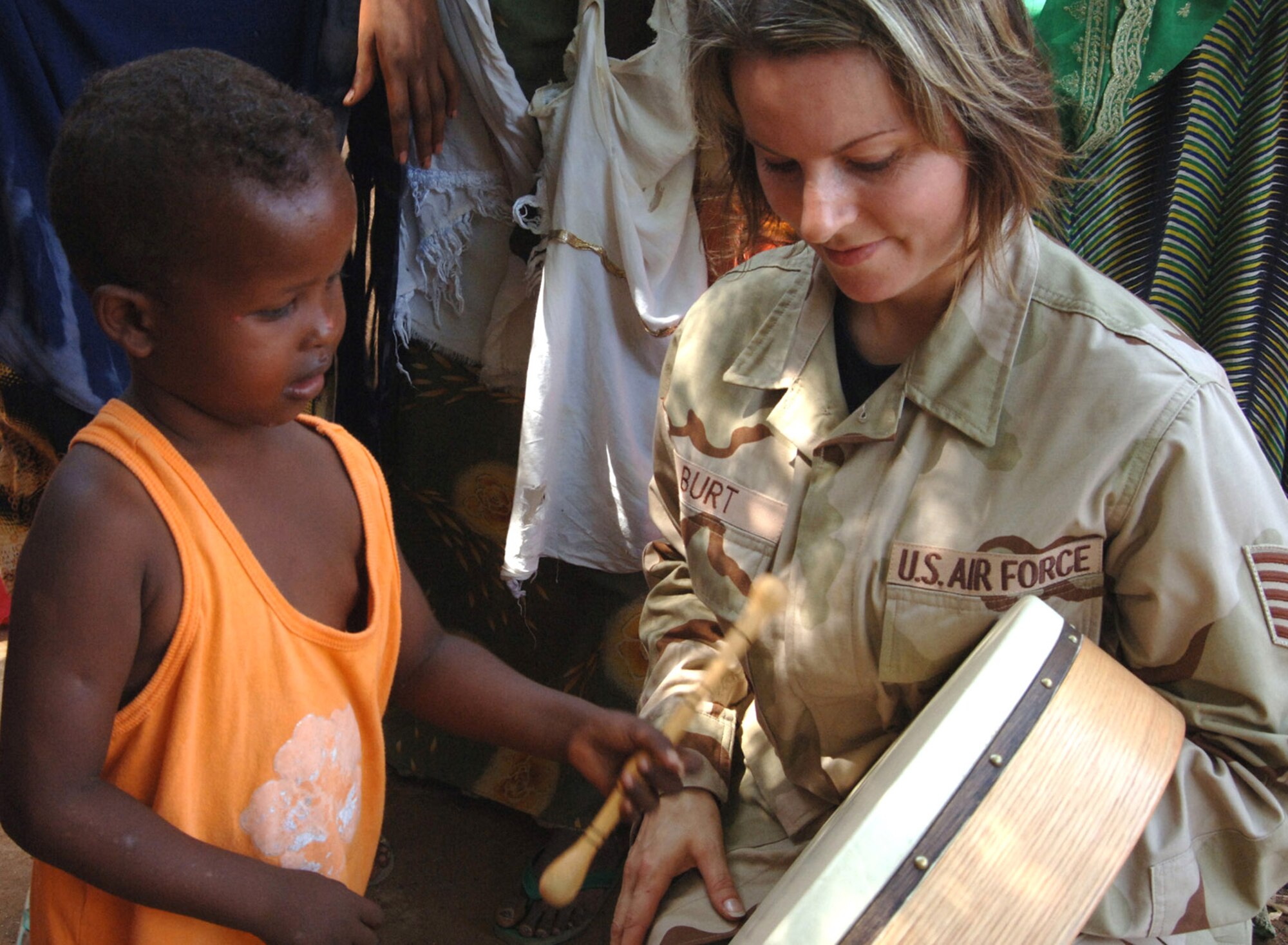 Tech. Sgt. Sherry Burt shows a child from the village of Damerjog, Djibouti, the djembe, an Irish drum, after performing with the U. S. Central Command Air Forces Expeditionary Band the "Desert Ramblers," for the locals Oct. 9. Sergeant Burt is a vocalist and Irish flute player. The band was in the area for a tour stop at Camp Lemonier, Djibouti. (U.S. Navy photo/Navy Petty Officer 2nd Class Regina L. Brown) 