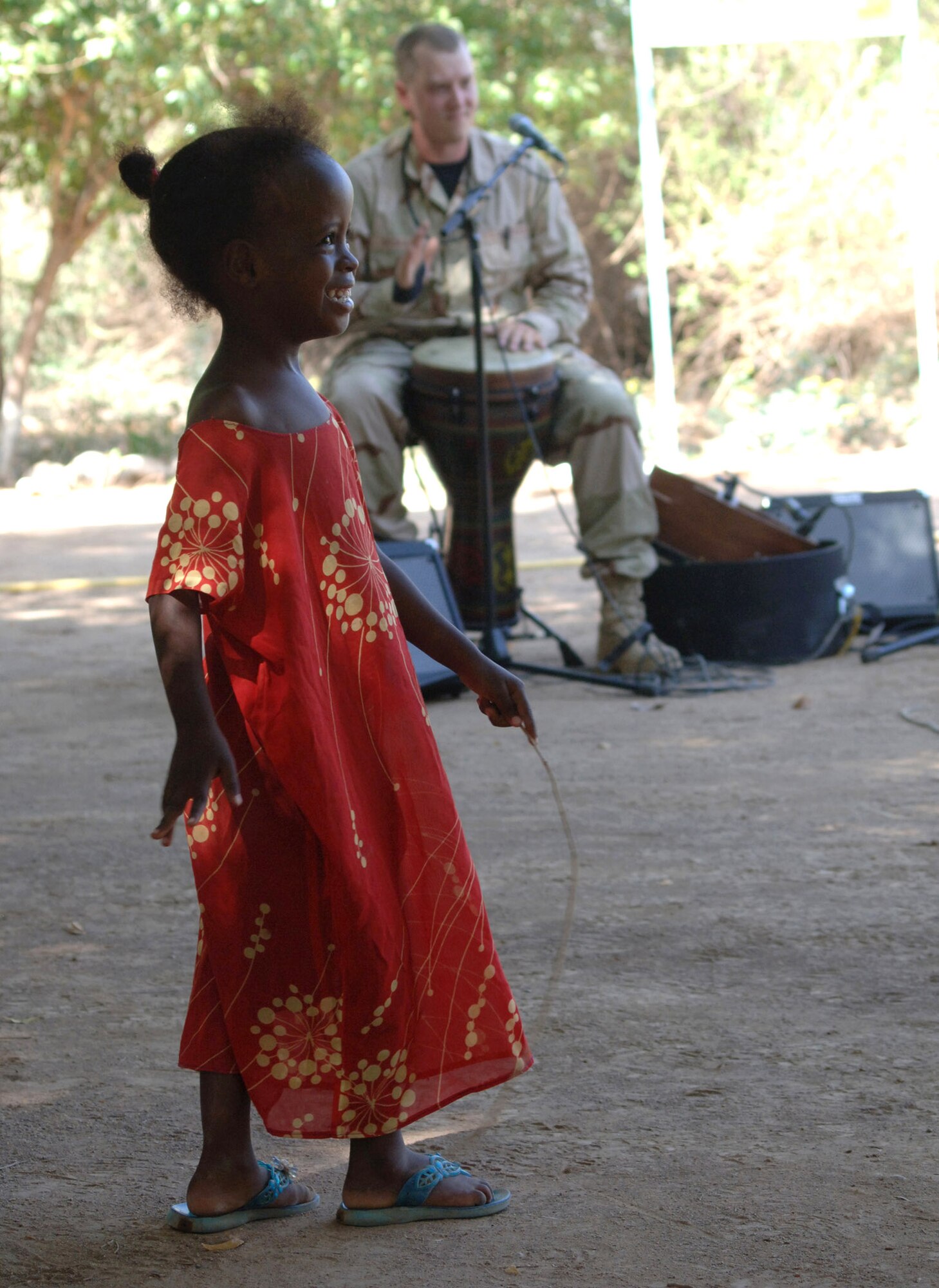 A young girl form the village of Damerjog, Djibouti, dances to music played by the U.S. Central Command Air Forces Expeditionary Band the "Desert Ramblers" Oct. 9.  The band was in the area for a tour stop at Camp Lemonier, Djibouti. (U.S. Navy photo/Navy Petty Officer 2nd Class Regina L. Brown)