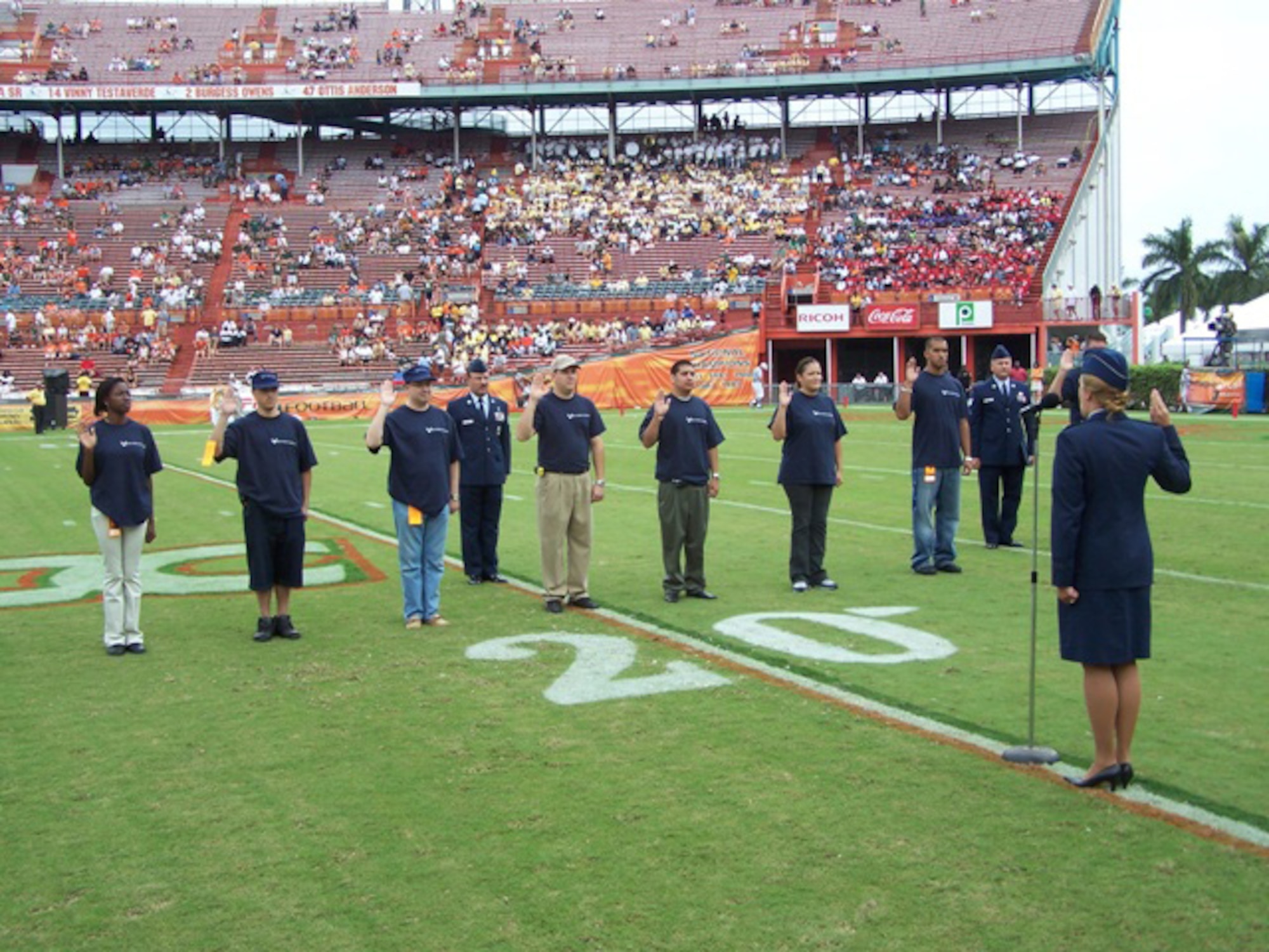 1st Lt. Katherine Easevoli, 482nd Fighter Wing executive officer, leads the oath of enlistment with nine Homestead reservists on the Orange Bowl field during the pre-game festivities of the University of Miami vs. Georgia Tech football game on Saturday. The 482nd Fighter Wing Recruiting Office sponsored the event, which also included a flyover by 93rd Fighter Squadron pilots. (U.S. Air Force photo/Senior Airman Erik Hofmeyer)