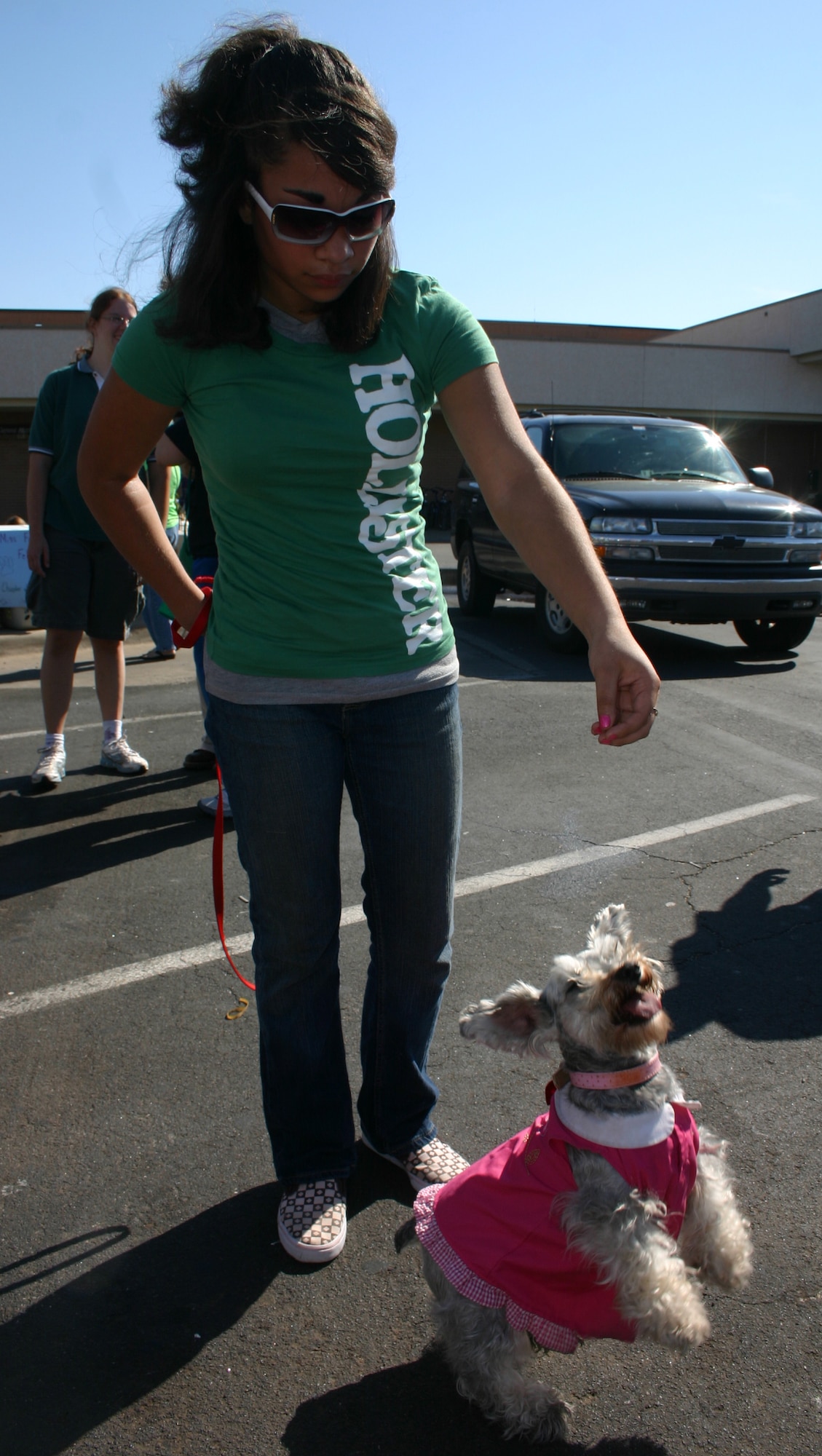 Reyna Thomas coaxes her dog, Sadie, into doing the dance that earned Sadie first place in the best trick category at the Dog Show in the base exchange parking lot Oct. 13. (U.S. Air Force photo/Staff Sgt. Tonnette Thompson)
