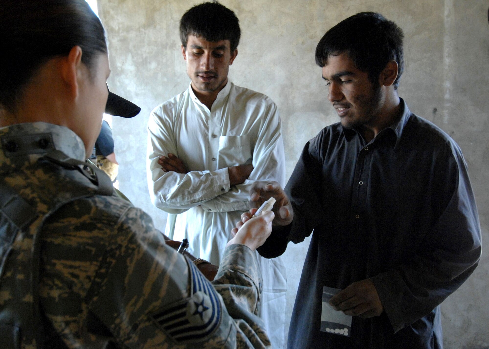 Tech. Sgt. Joy Flumerfelt provides medicine to local Afghanistan villigers Oct. 4 during a medical civil action project near Bagram Air Base, Afghanistan. Sergeant Flumerfelt is a medical technician with the 455th Air Expeditionary Wing. (U.S. Air Force photo/Staff Sgt. Joshua T. Jasper)