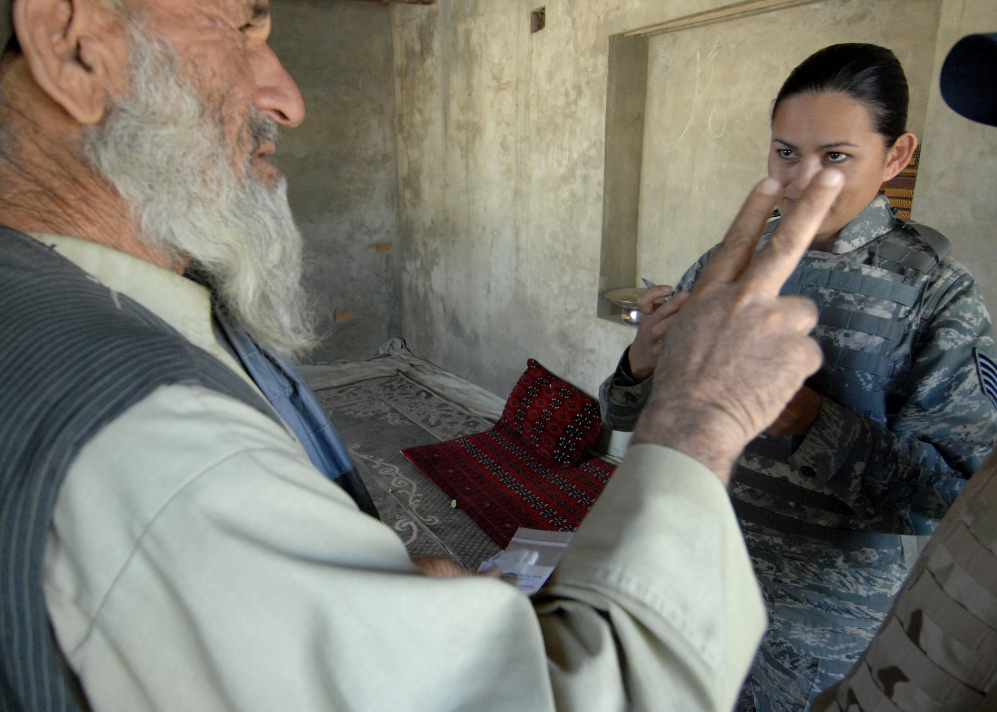 Tech. Sgt. Joy Flumerfelt listens to a villager as he explains his symptoms at a medical civil action project held Oct. 4 at a small village near Bagram Air Base, Afghanistan. Sergeant Flumerfelt is a medical technician with the 455th Air Expeditionary Wing. (U.S. Air Force photo/Staff Sgt. Joshua T. Jasper)
